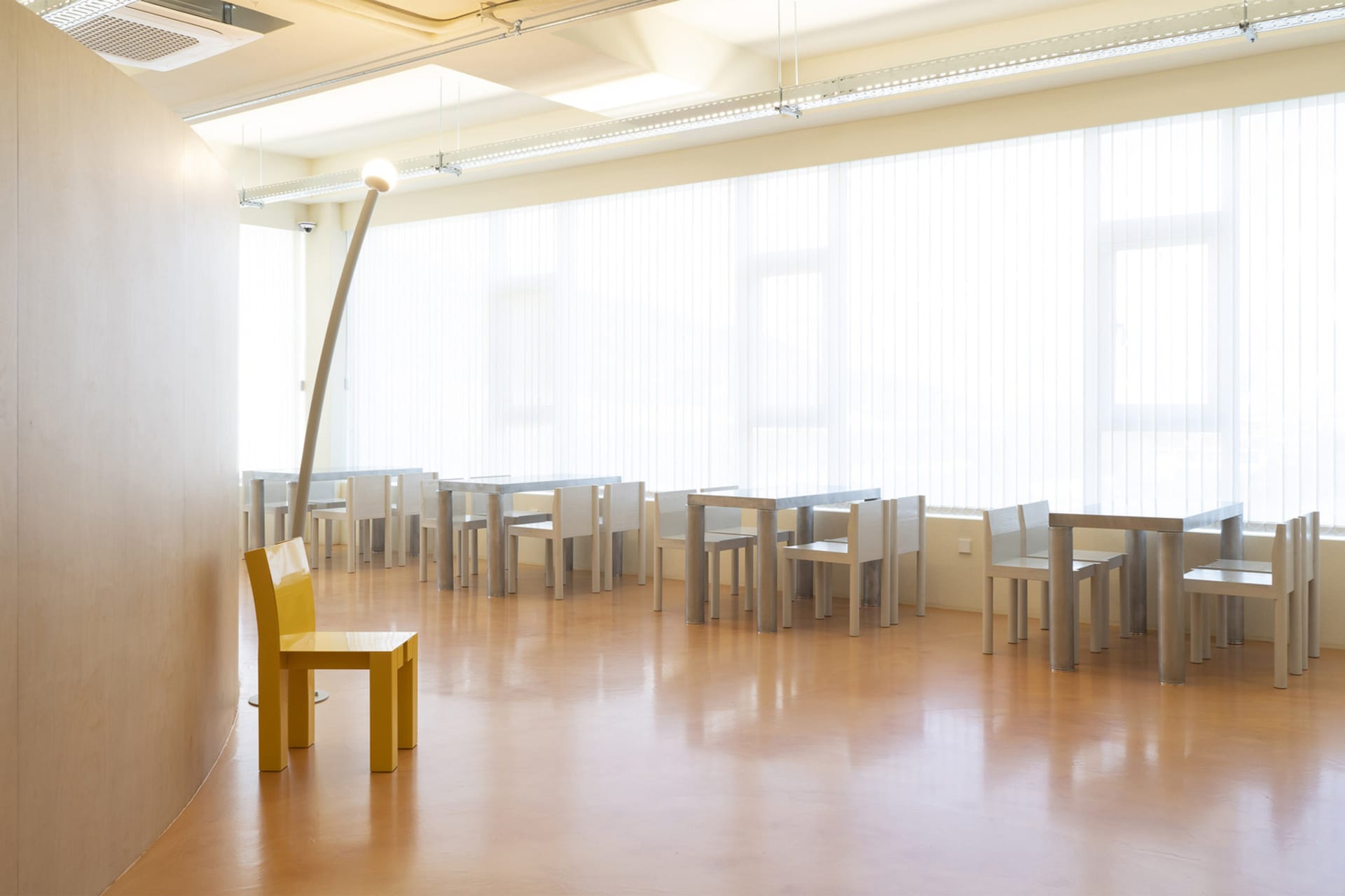 A well-lit classroom with multiple chairs in various positions, conveying a sense of organization and functionality