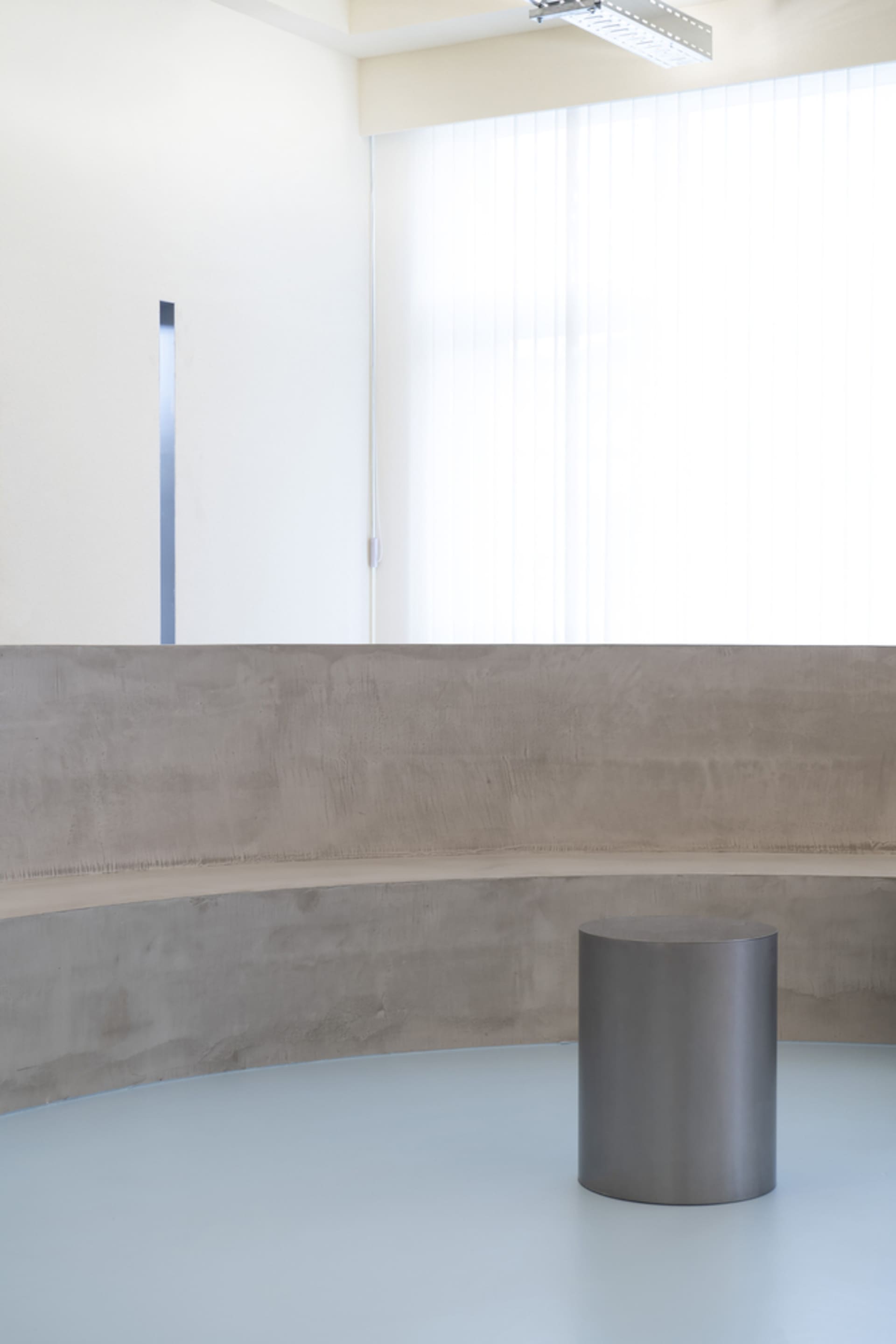 Empty minimalist room with a concrete bench in the center, featuring a simple, functional space with no decorative elements or additional features