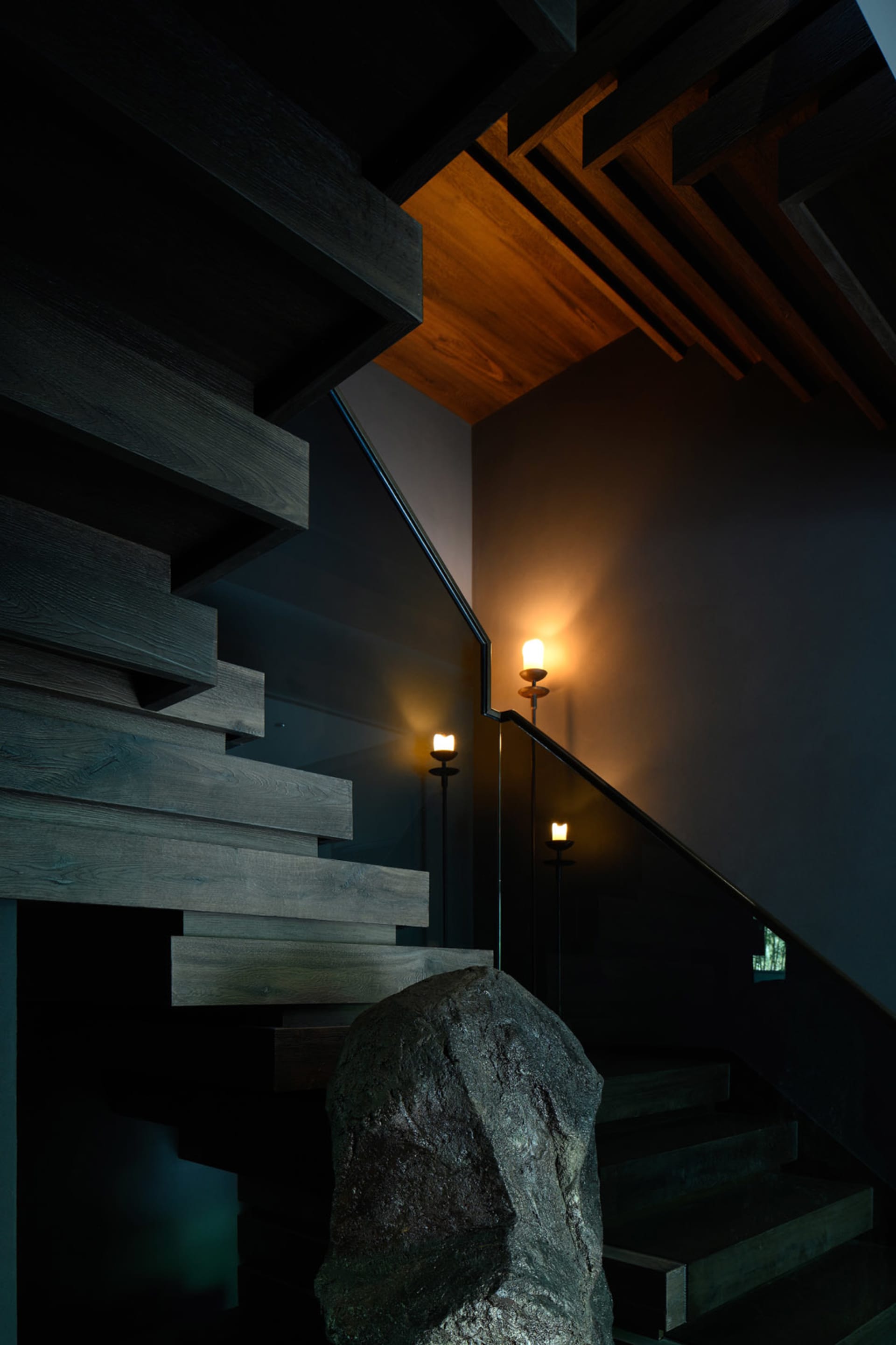 A darkened room with two sets of wooden stairs leading to different levels, creating a mysterious atmosphere