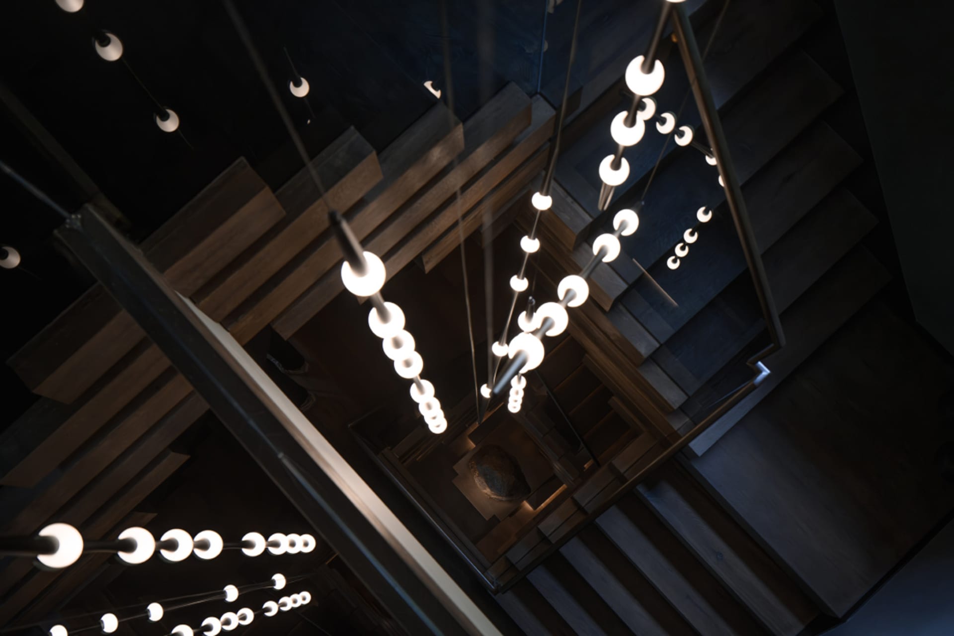 A modern hotel stairwell with wooden steps and lights, creating a well-lit atmosphere