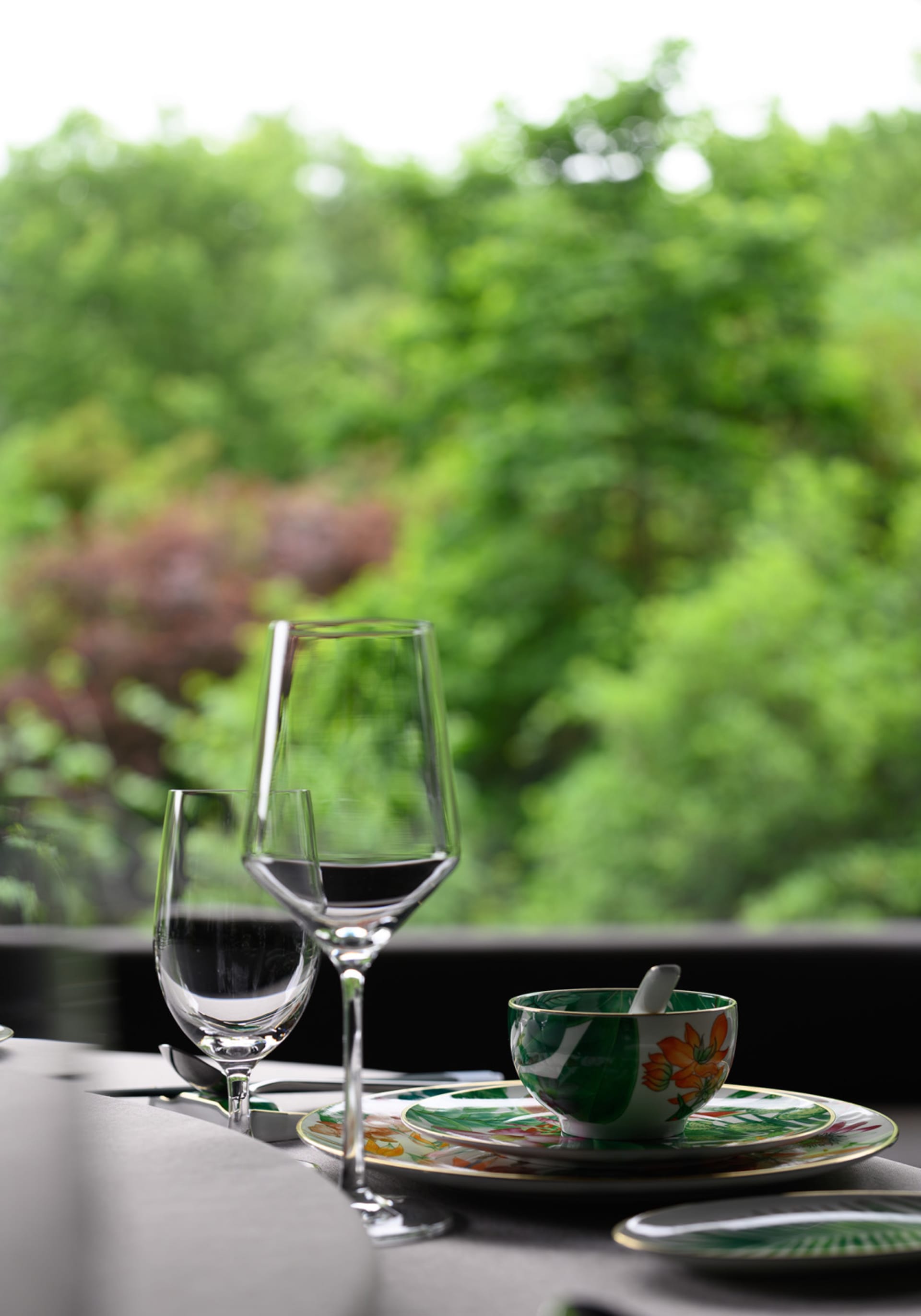 A well-arranged dining table with wine glasses and a bowl, set in a cozy room with inviting atmosphere