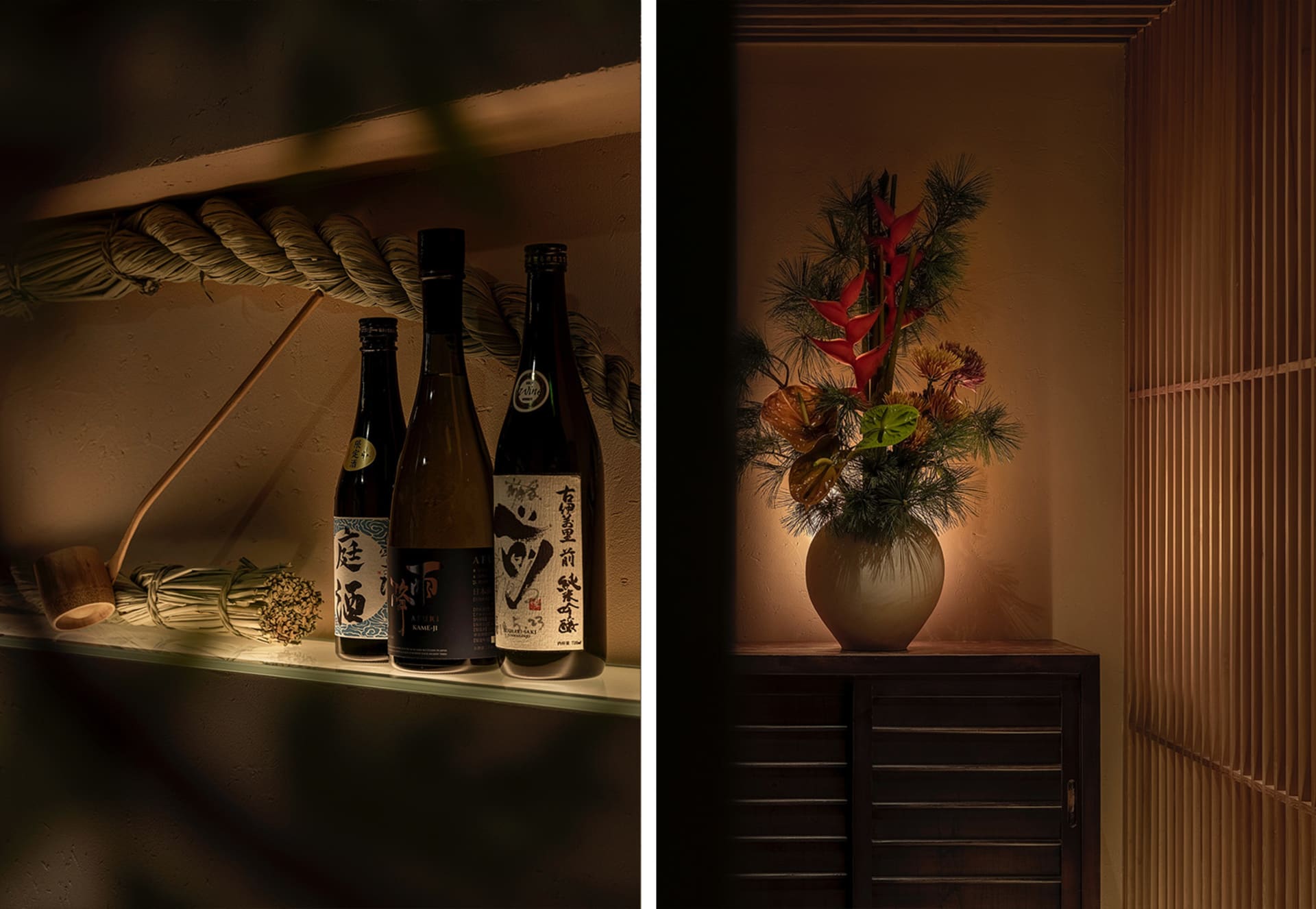 A table with a vase of red flowers and several bottles arranged in a row, creating a cozy and inviting atmosphere