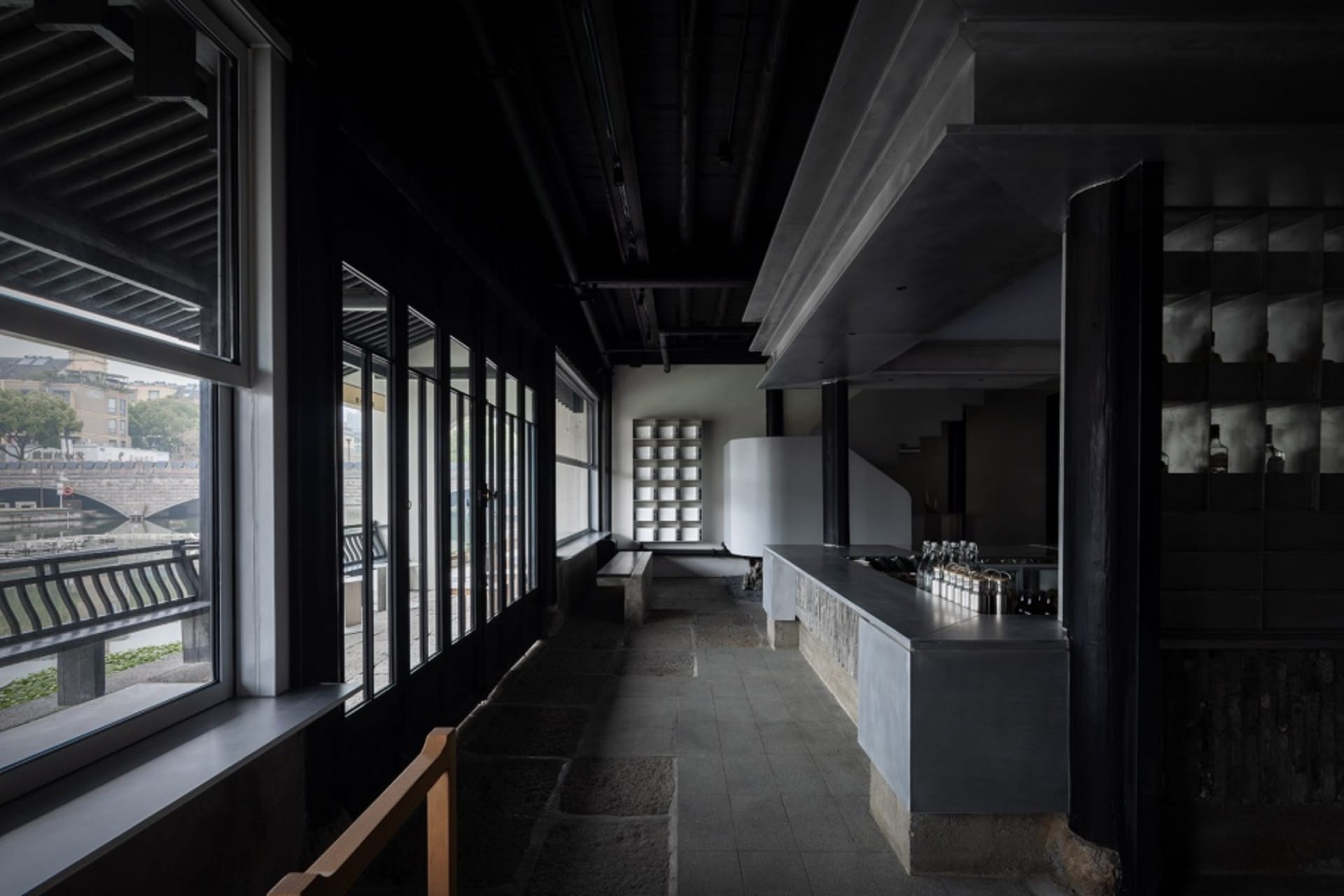 Modern bar area with a countertop, multiple bottles, and benches, giving a stylish and welcoming atmosphere