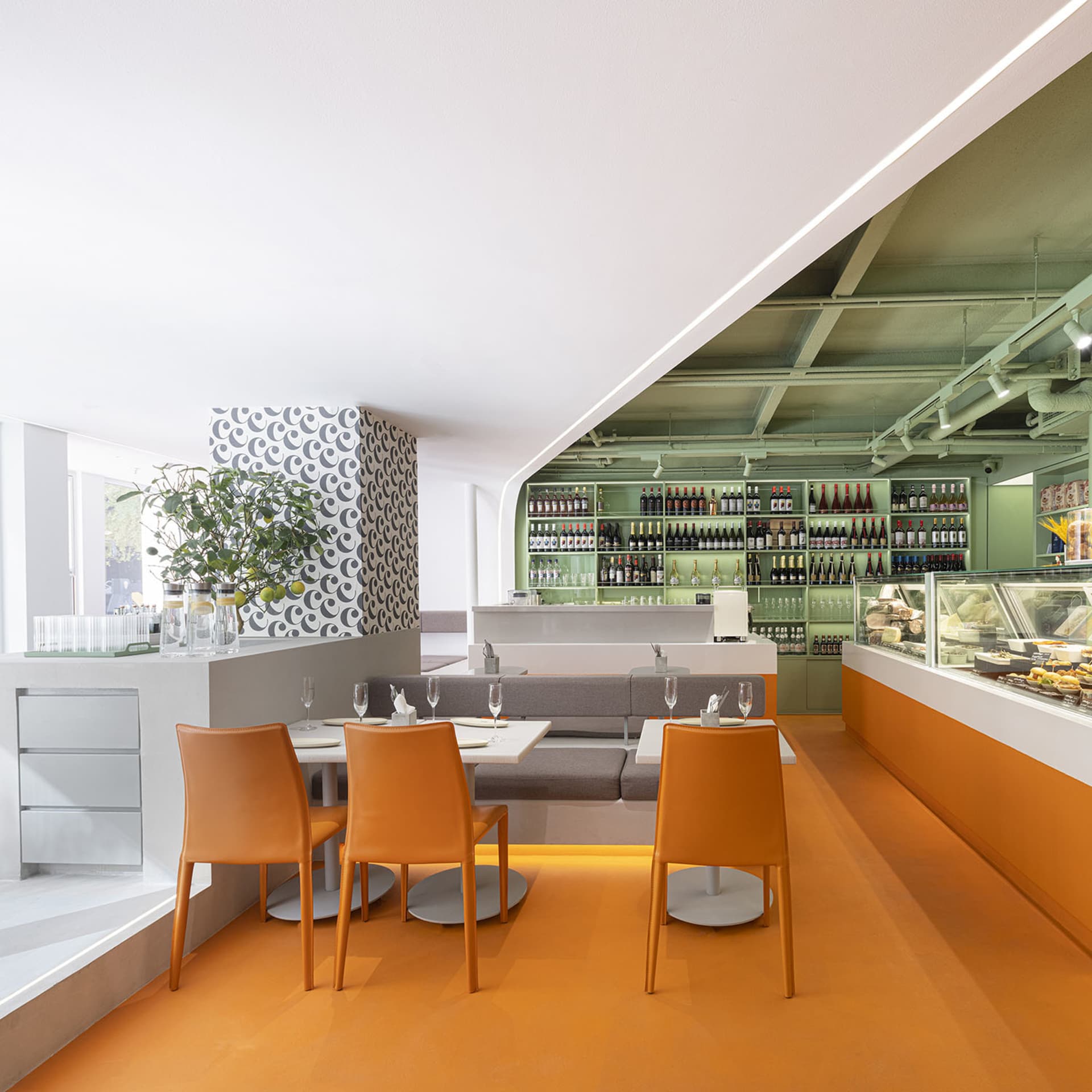 Warm and inviting dining space with an orange background, a large wooden dining table, and wine glasses on the table