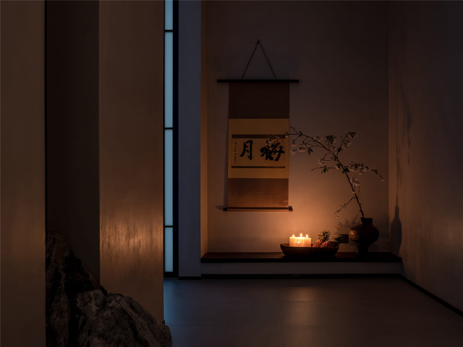 Asian-style living space with a tatami mat on a hardwood floor, featuring vases and a potted plant in a calm and serene atmosphere