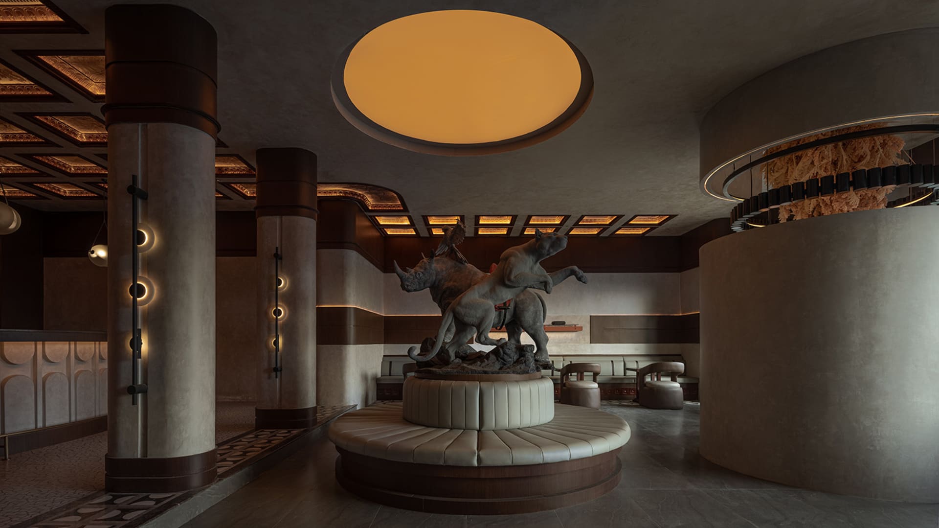 A circular room with a marble statue, chairs, and a sophisticated atmosphere, inviting visitors to appreciate the artwork on display