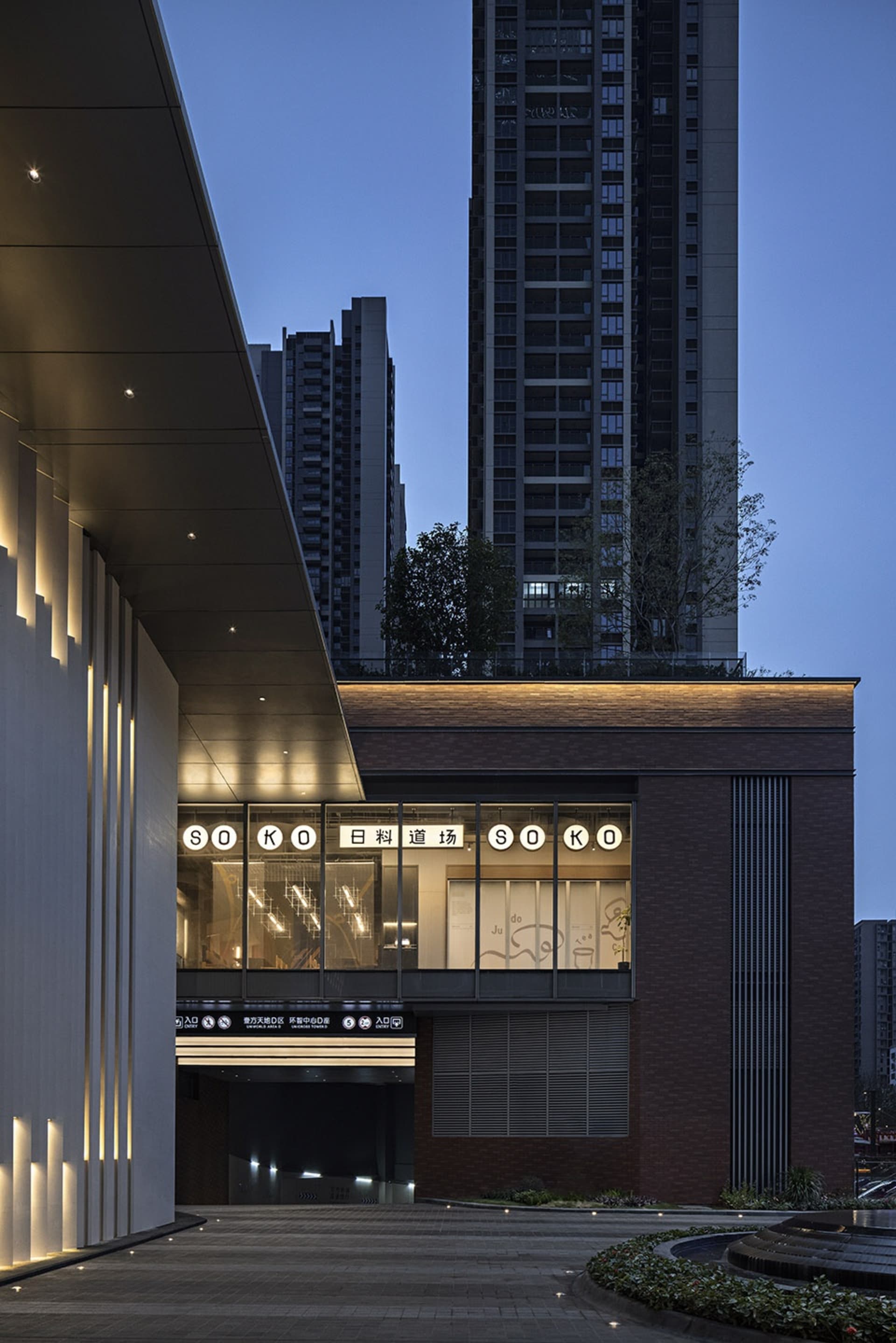 A large brick building with a modern design, featuring a prominent glass window and multiple levels, with a sense of grandeur and sophistication