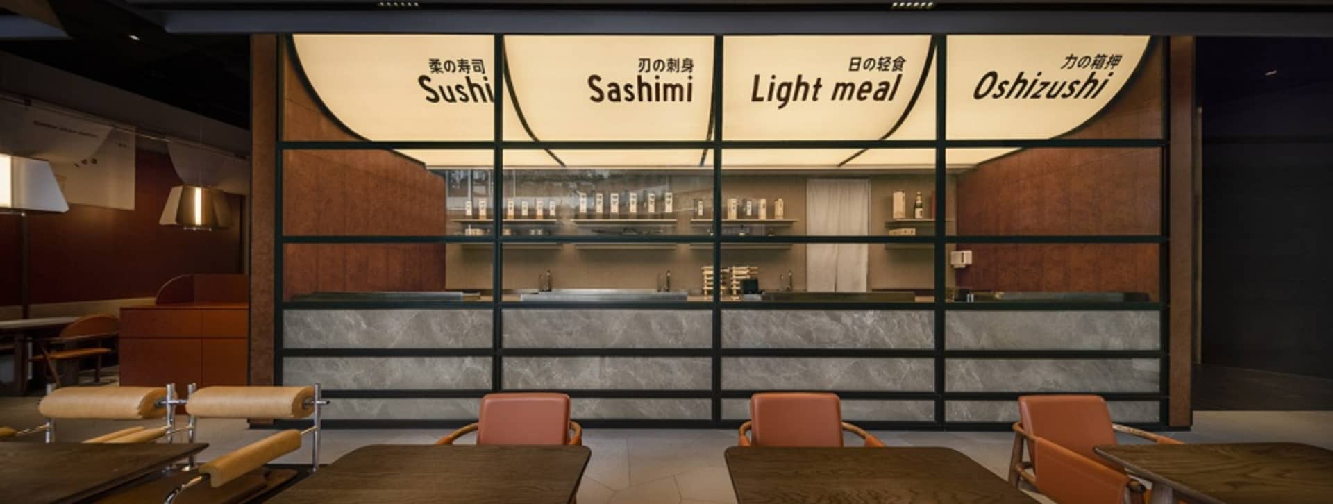 Modern Asian restaurant with a marble counter, sushi bar, and Japanese writing on the walls, creating an inviting atmosphere