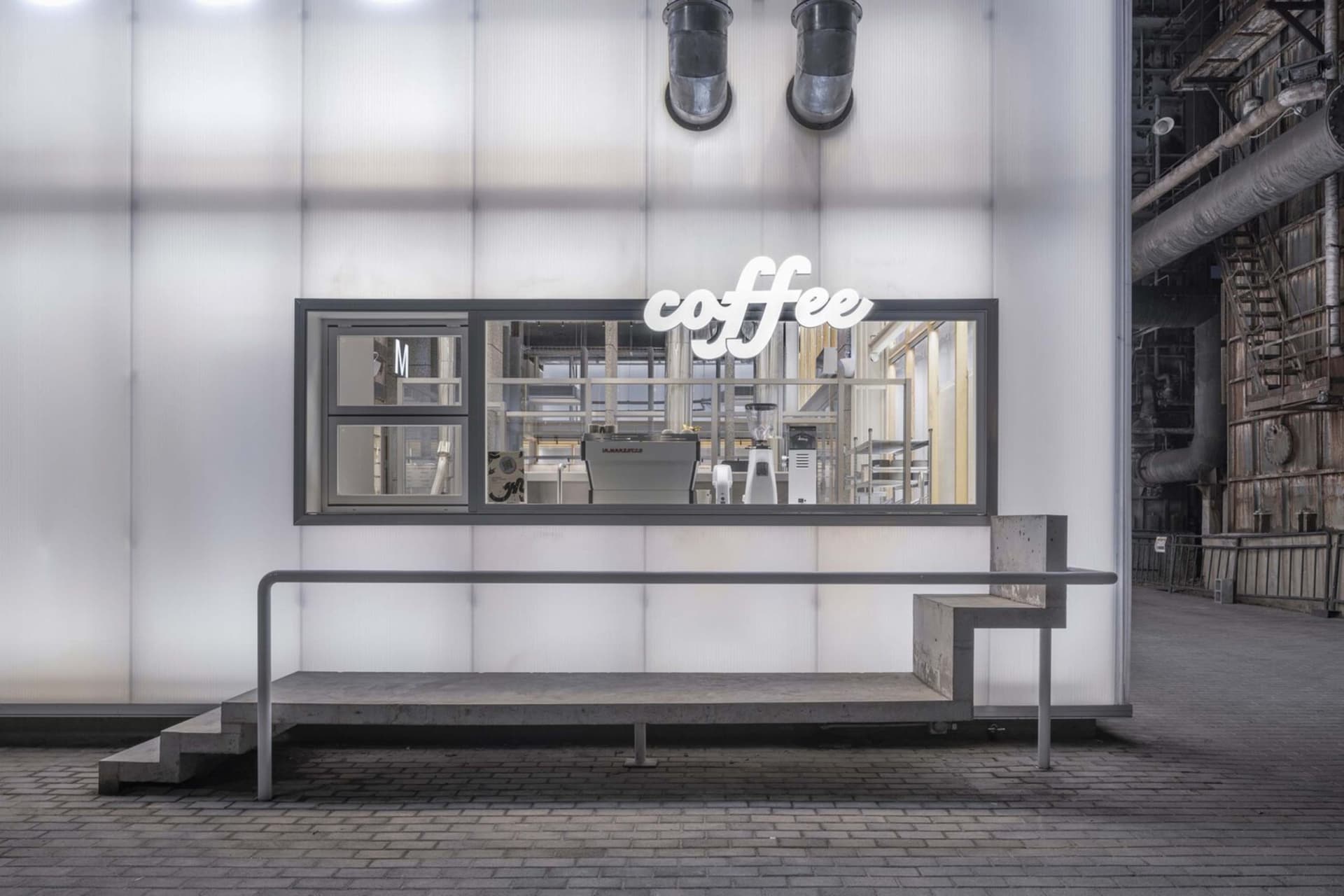 Industrial coffee processing facility with metal and glass surfaces, natural light, and machinery