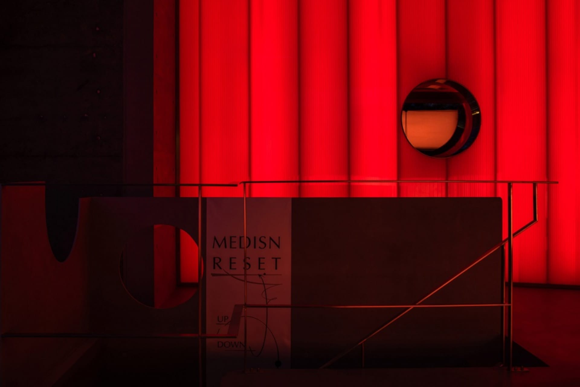 A futuristic interior space with a red lit wall, two round decorative elements, and a striking visual impact from vibrant colors and intriguing shapes
