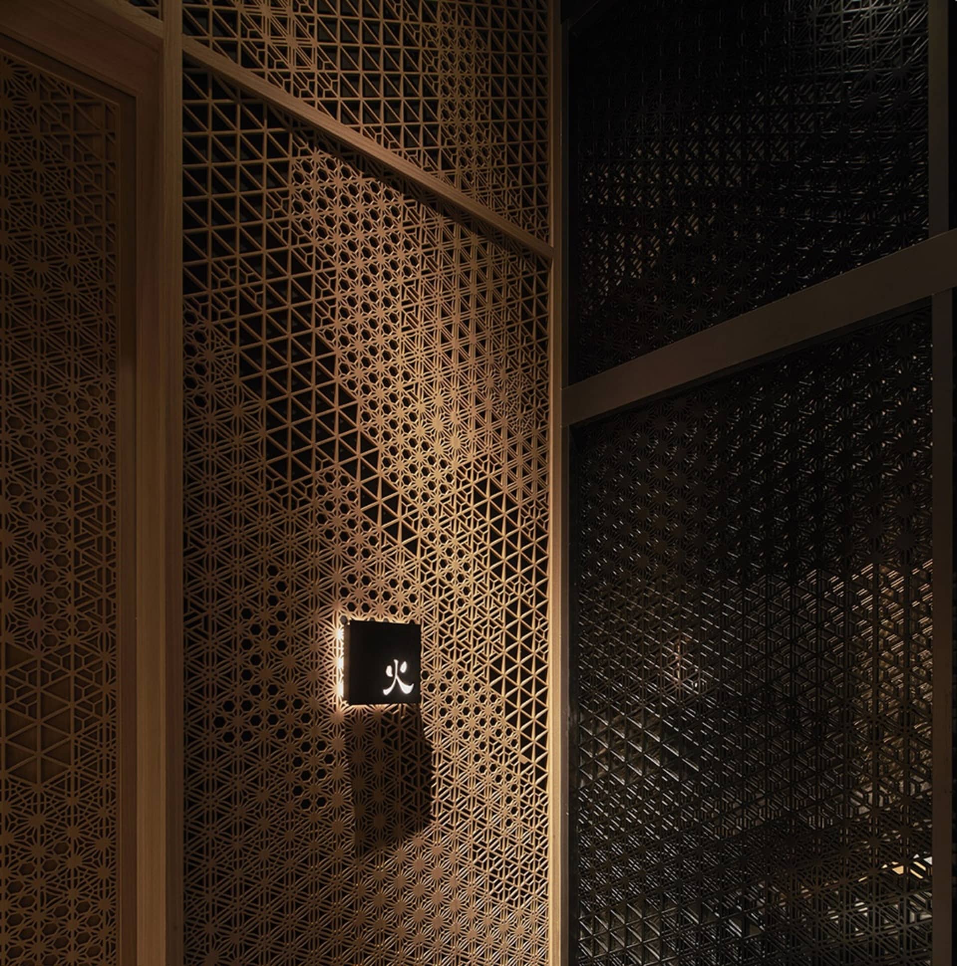 Interior space with a hexagonal patterned wall, wooden walls, and two doors, creating an inviting and comfortable atmosphere