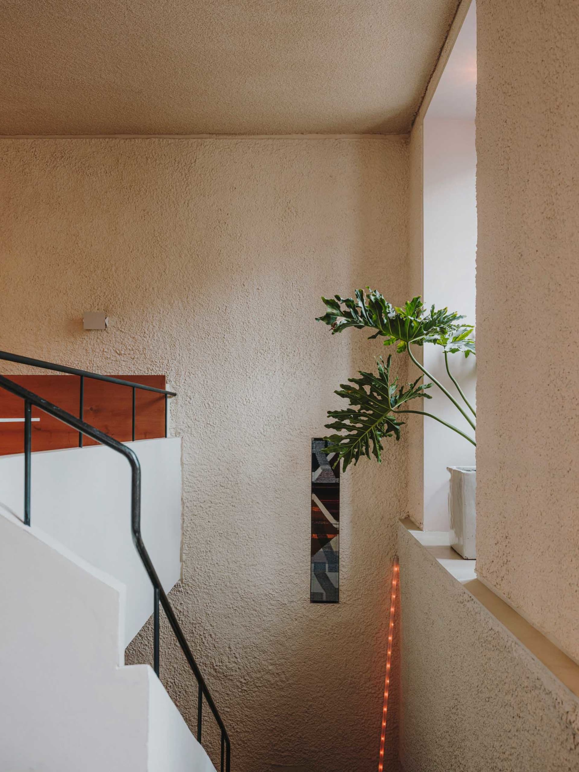 A warm and inviting interior space with a staircase leading to another level, featuring wooden stairs and a cozy atmosphere