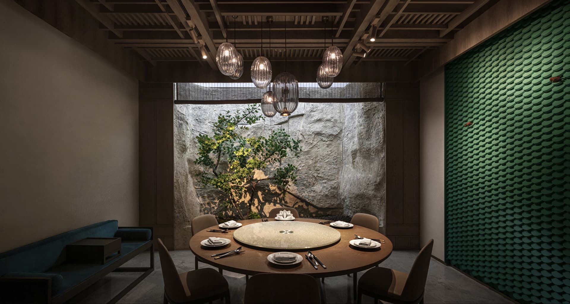 A modern dining space with a round table surrounded by chairs, a centerpiece featuring a tree, and a sophisticated atmosphere