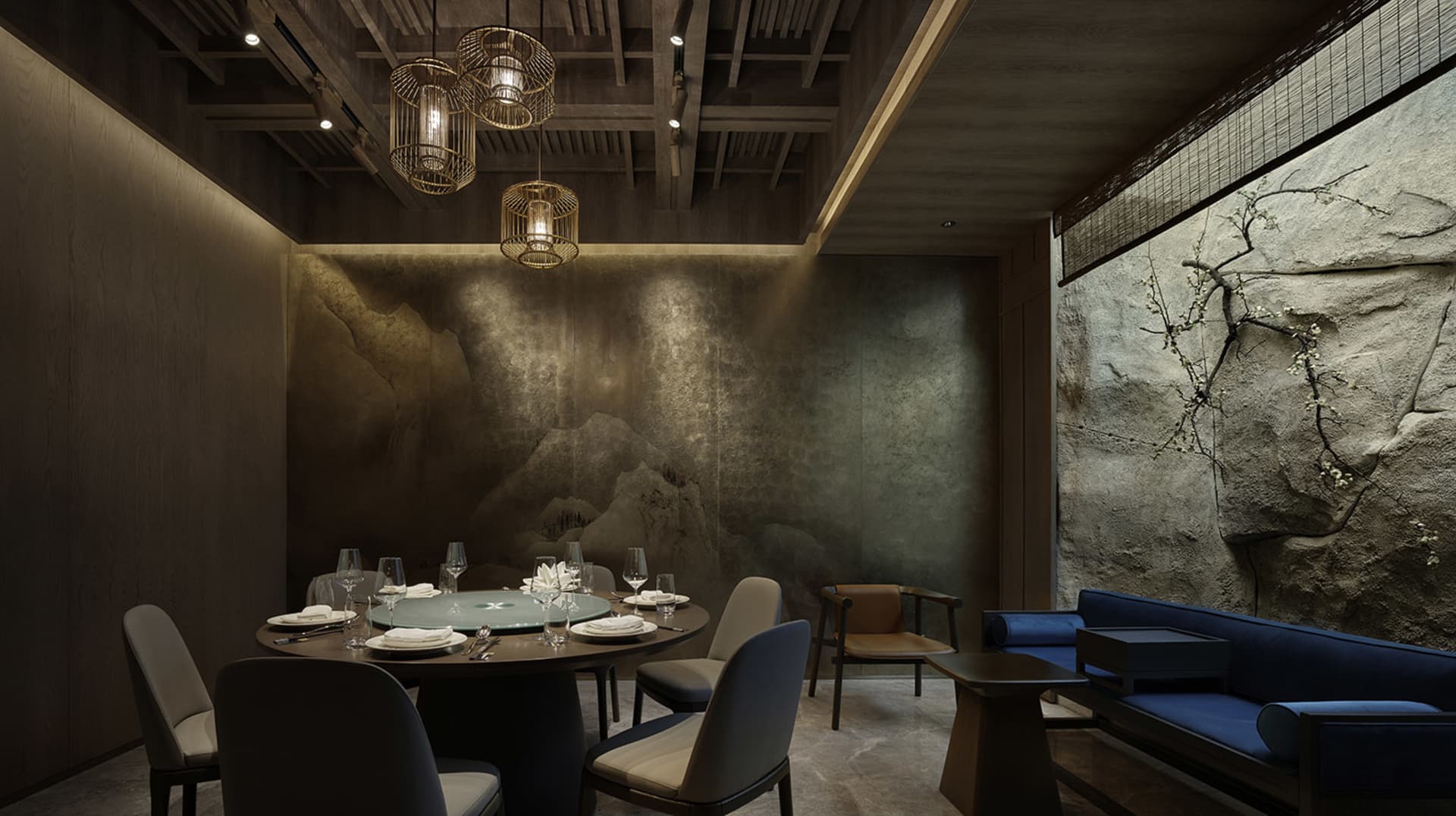 現代圓桌餐廳區域，配有椅子、酒杯與杯具，周圍環繞木質與金屬元素，牆面帶灰調