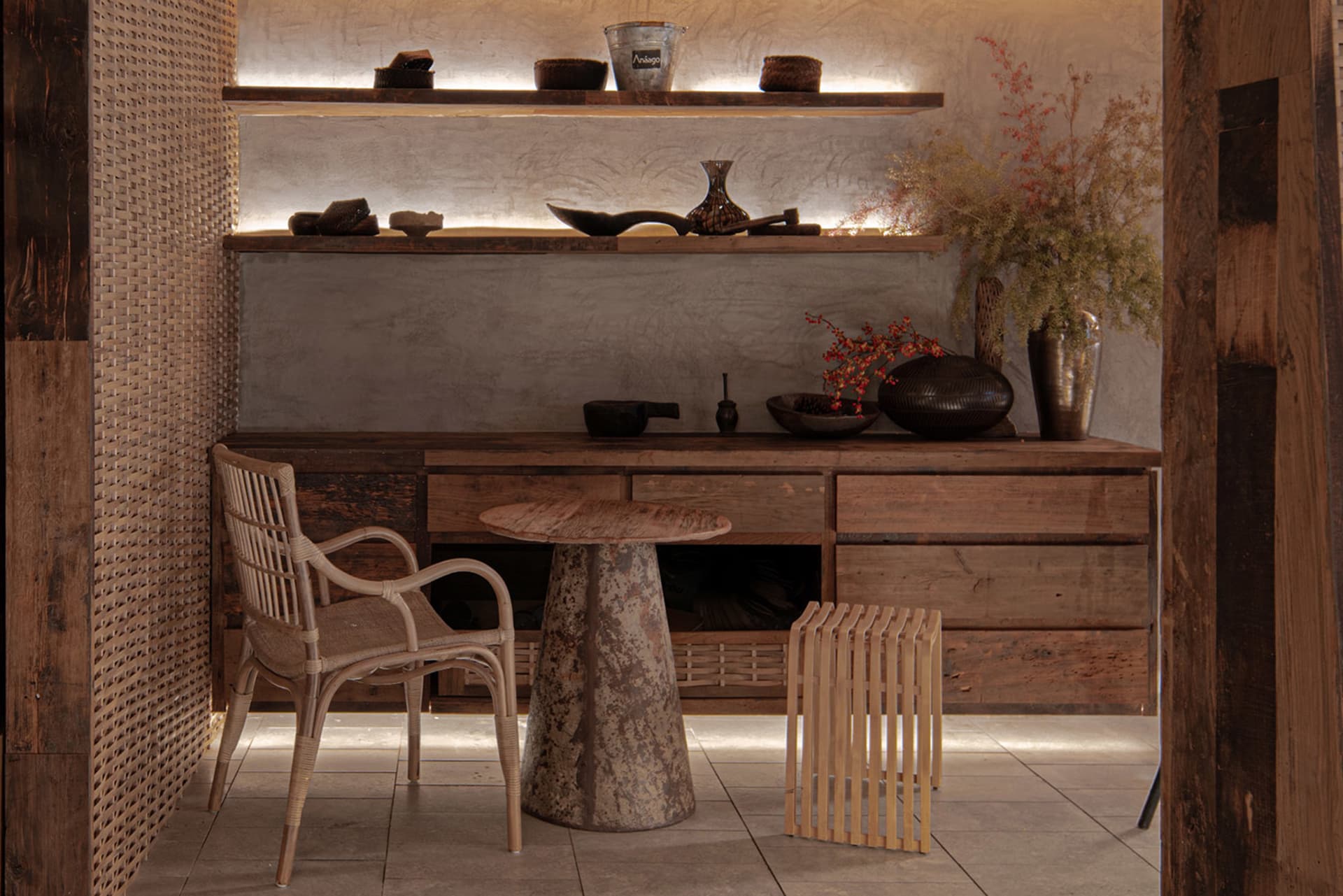 A well-lit living area with wooden floors, a dining table, chairs, and decorative vases and bowls, creating a warm and inviting atmosphere