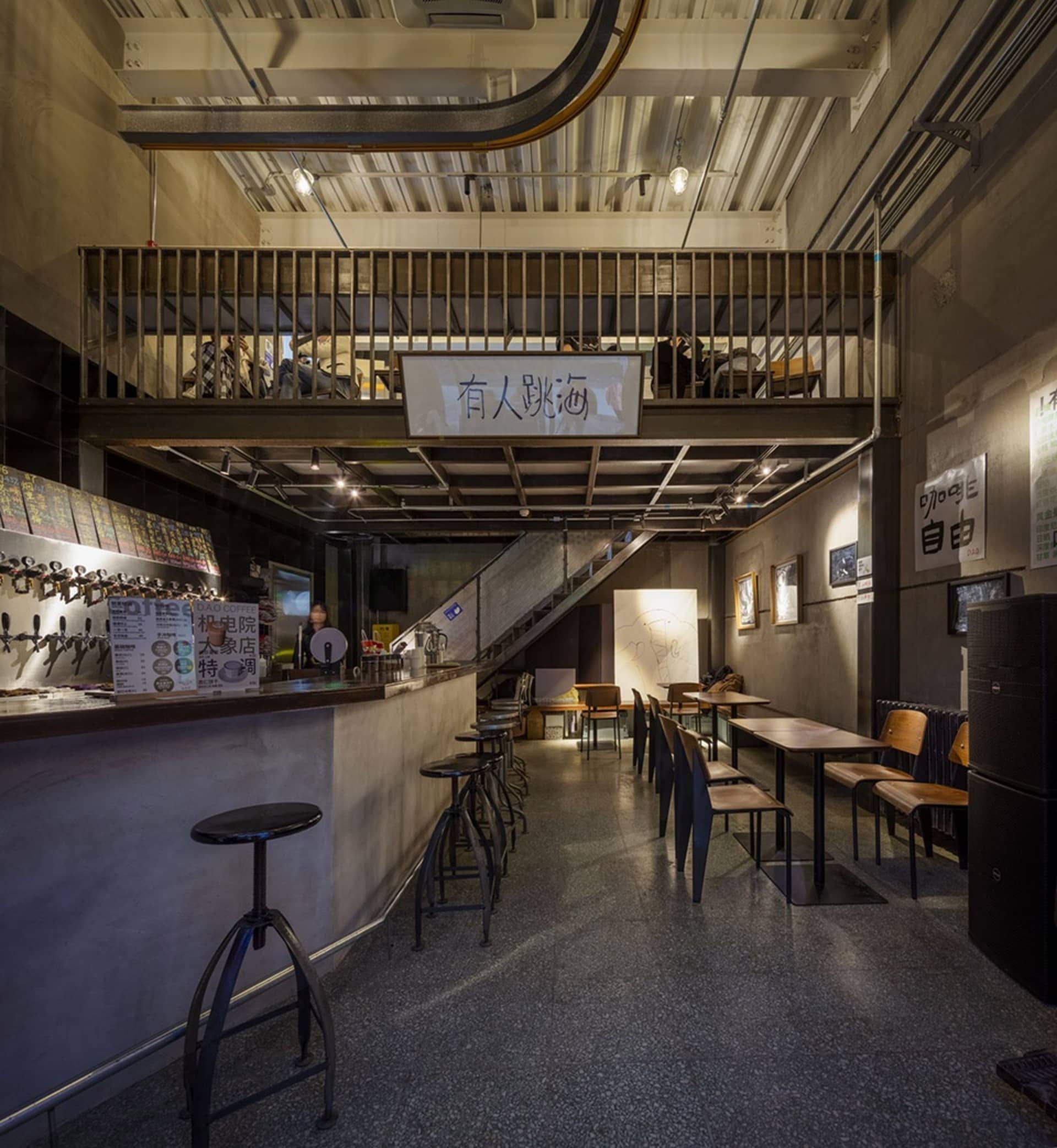 A casual restaurant with multiple dining tables and chairs, bottles on surfaces, and a warm atmosphere
