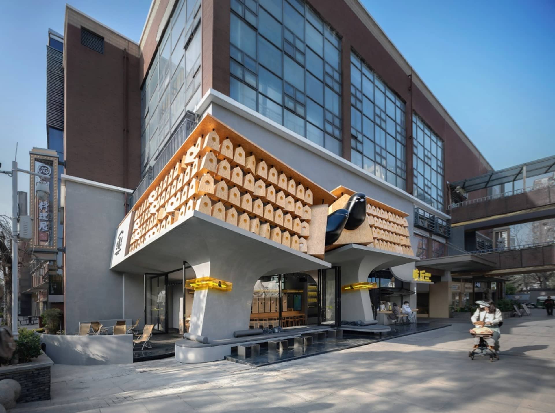 A modern building with a unique exterior featuring numerous small boxes attached to its concrete wall, set in a minimalist style with a focus on functionality