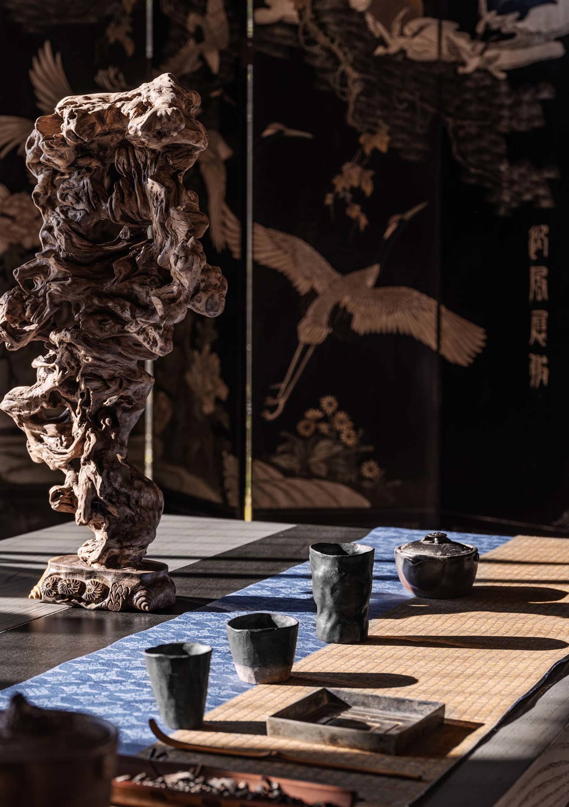 an oriental interior design featuring a wooden table with several bowls and a vase, blending traditional and modern elements
