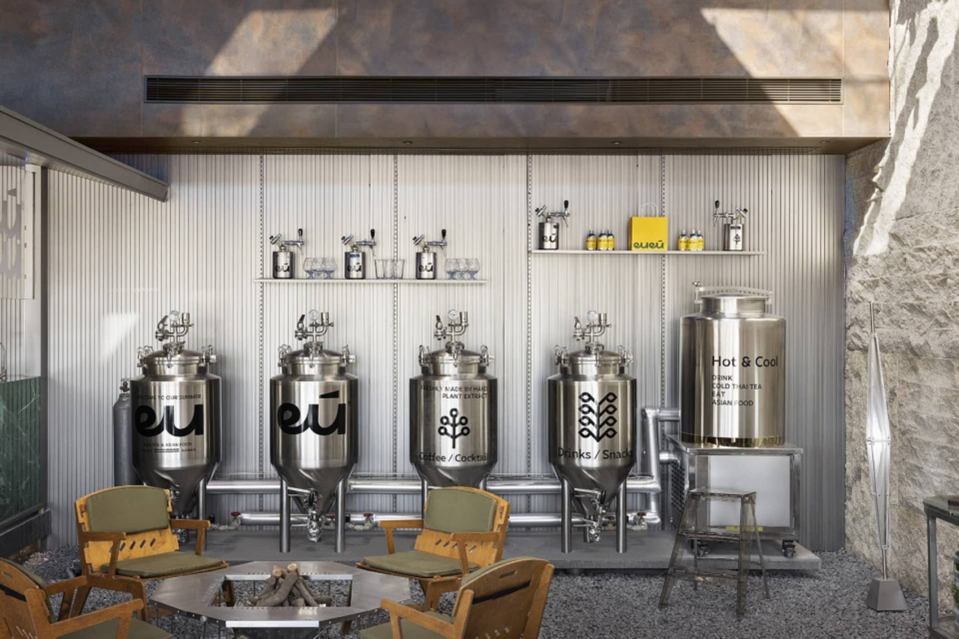 Industrial workspace with metal vats and chairs in a factory or warehouse setting, suggesting a functional and practical environment for productivity