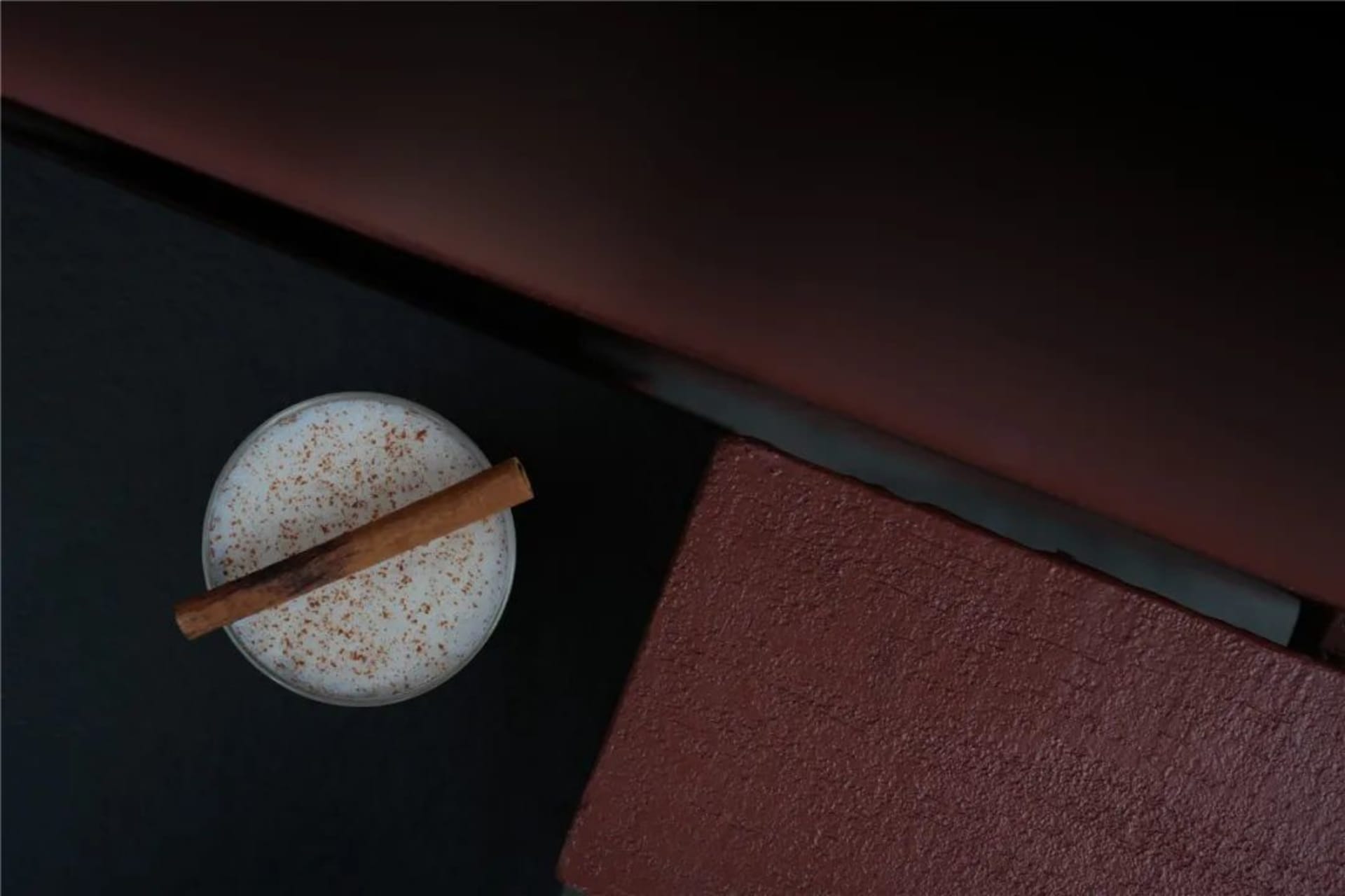 舒適客廳空間，配有沙發、桌台與溫暖燈光，點綴一杯牛奶與肉桂棒
