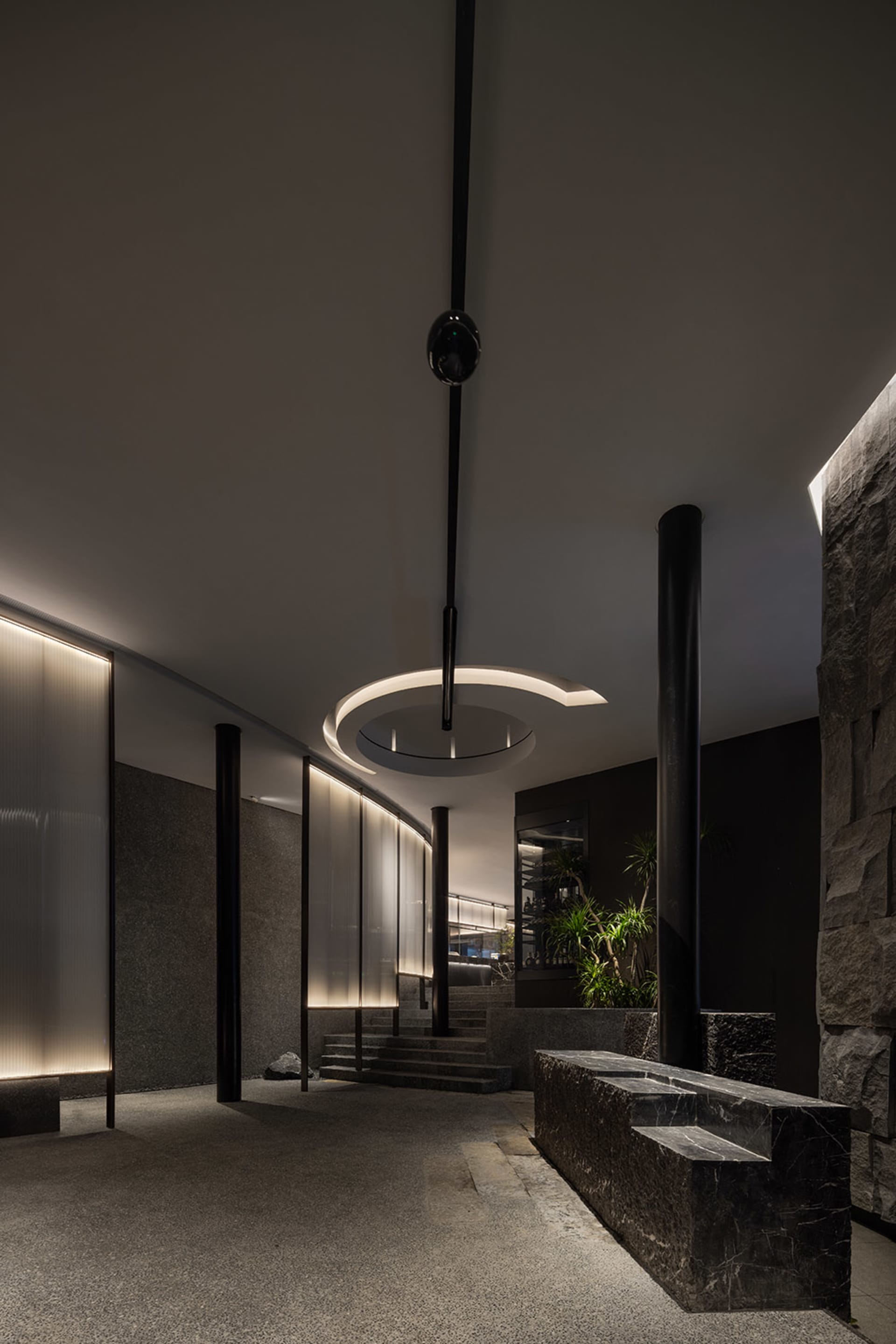 A well-designed interior space with a stone staircase, two potted plants, and a sense of sophistication