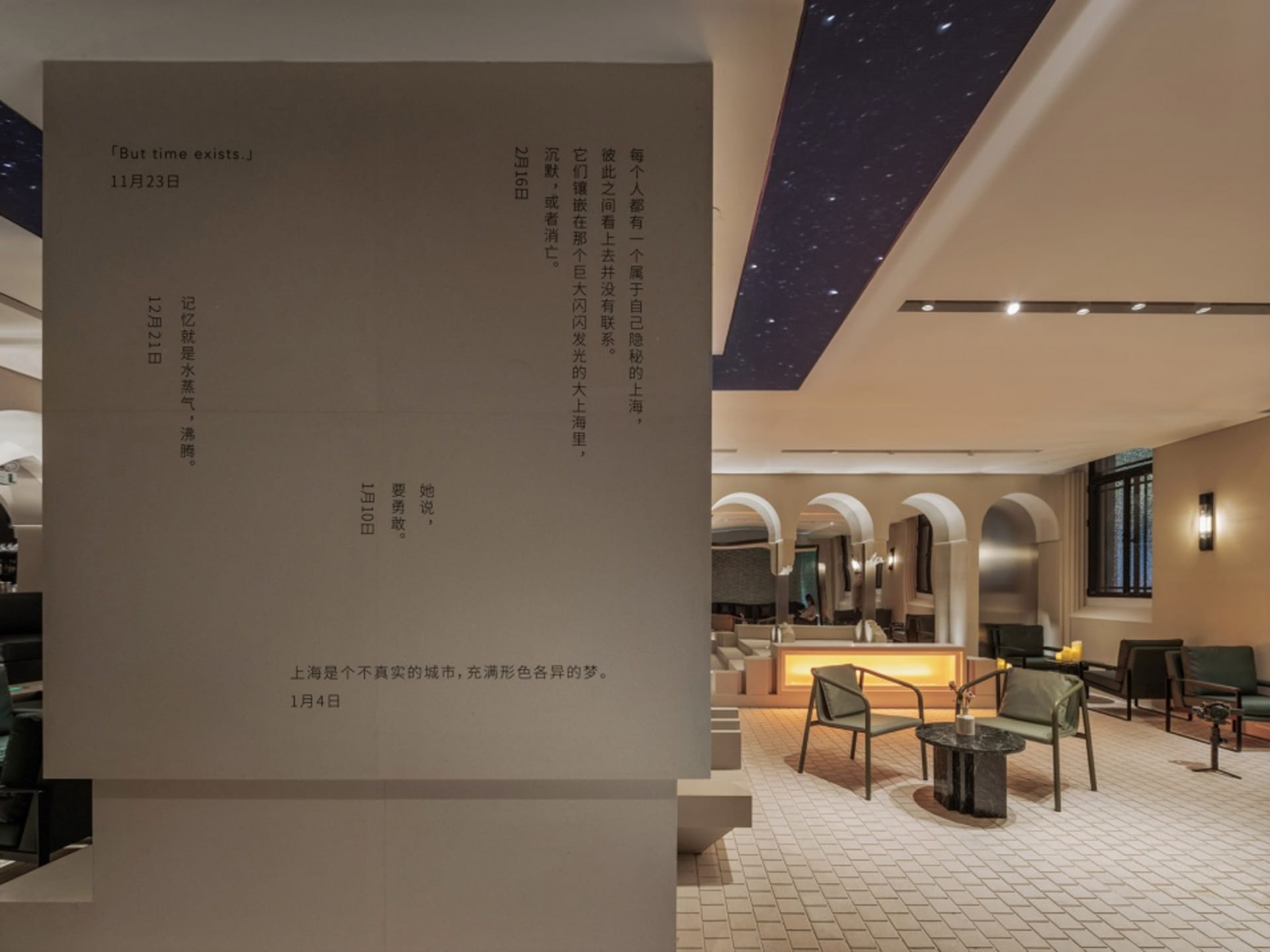 Calm and inviting lobby with stone walls, chairs, and a dining table, perfect for gathering and relaxation
