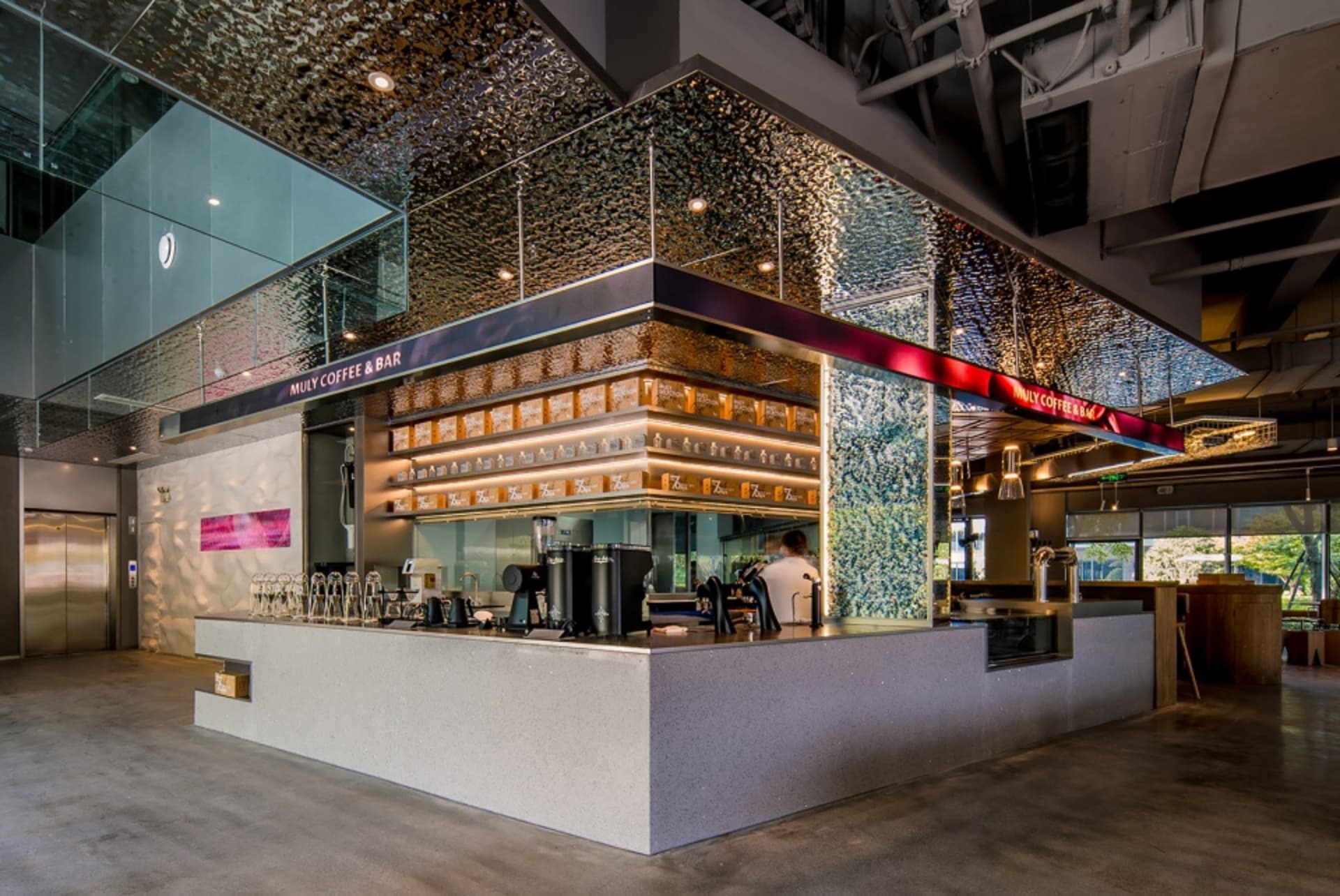 A cozy coffee shop interior with a bar area, chairs, cups, and bottles, creating a welcoming atmosphere for customers