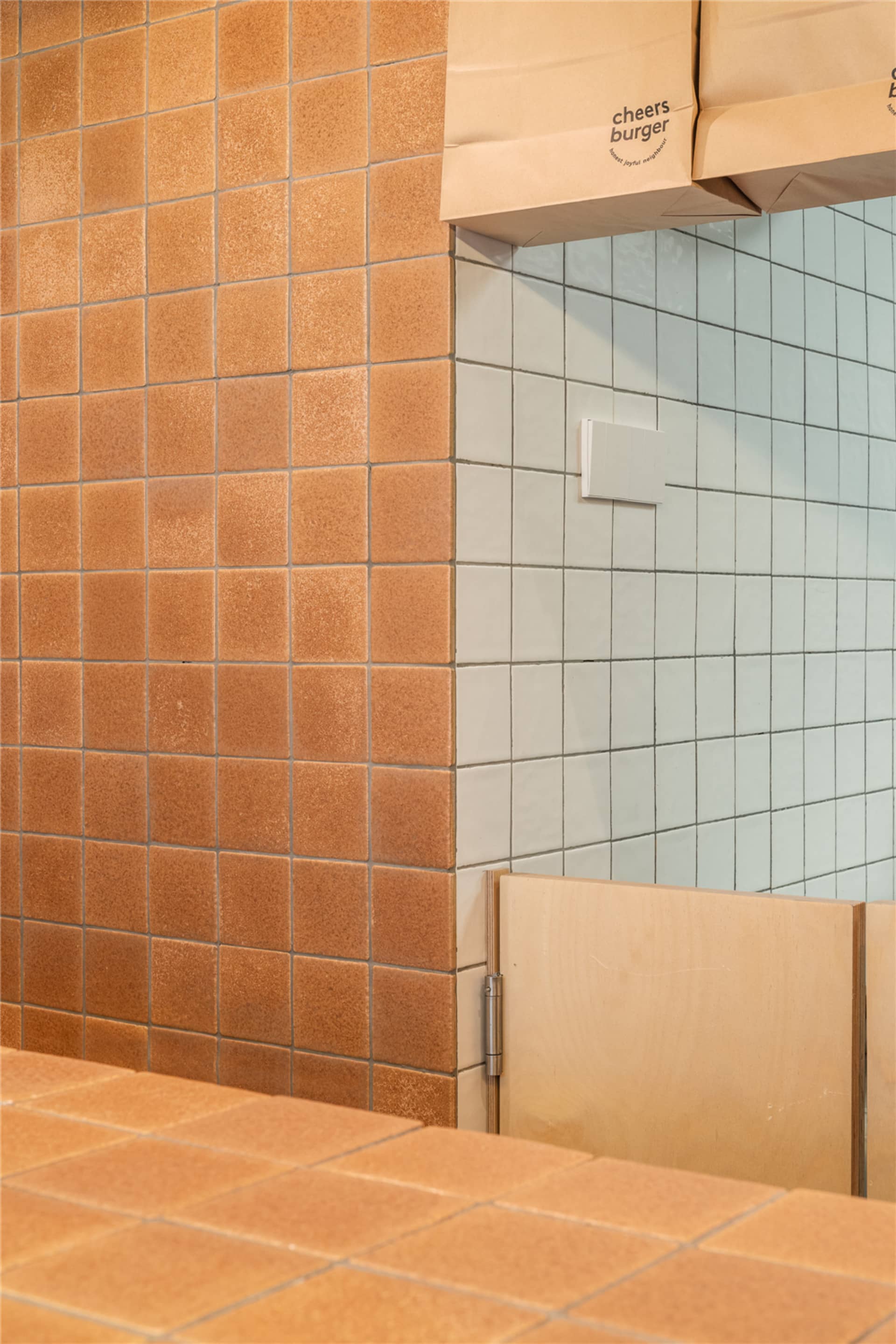 Bathroom with a brick-patterned wall, two sinks, and a bench, creating a clean and organized space with a focus on functionality and aesthetics
