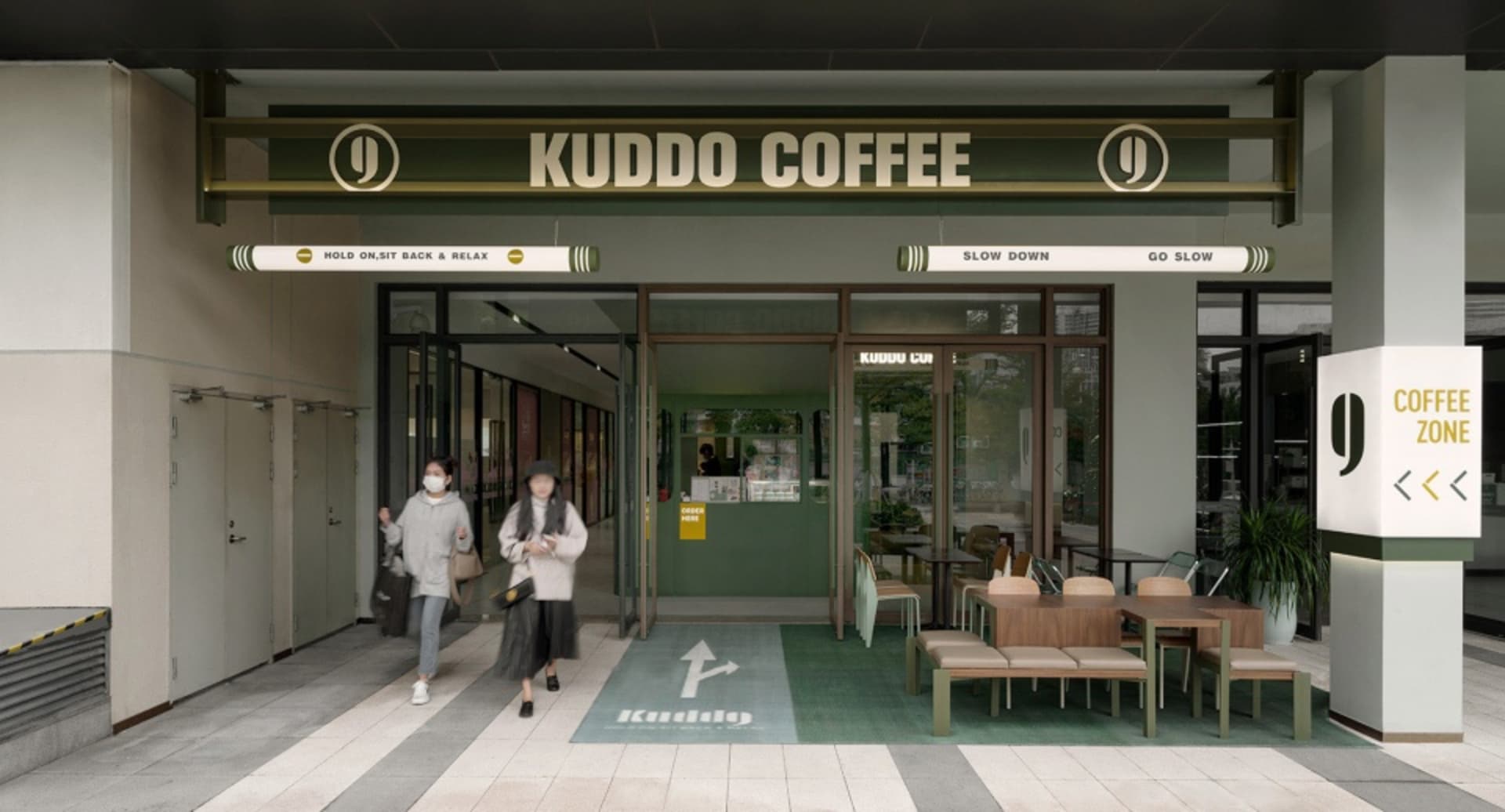 綠白主題的咖啡店，配有椅子與餐桌，氛圍溫馨誘人，一位女子正在走進