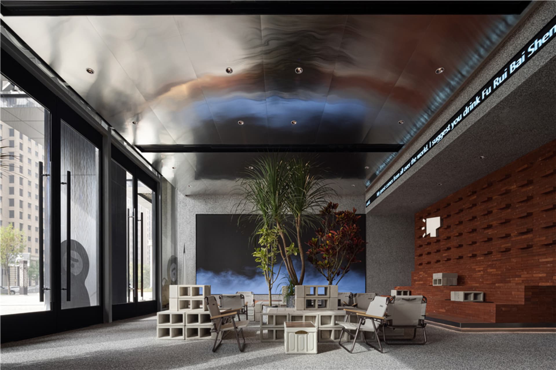 A large room with a dining table and chairs, surrounded by potted plants, creating a comfortable and relaxing atmosphere