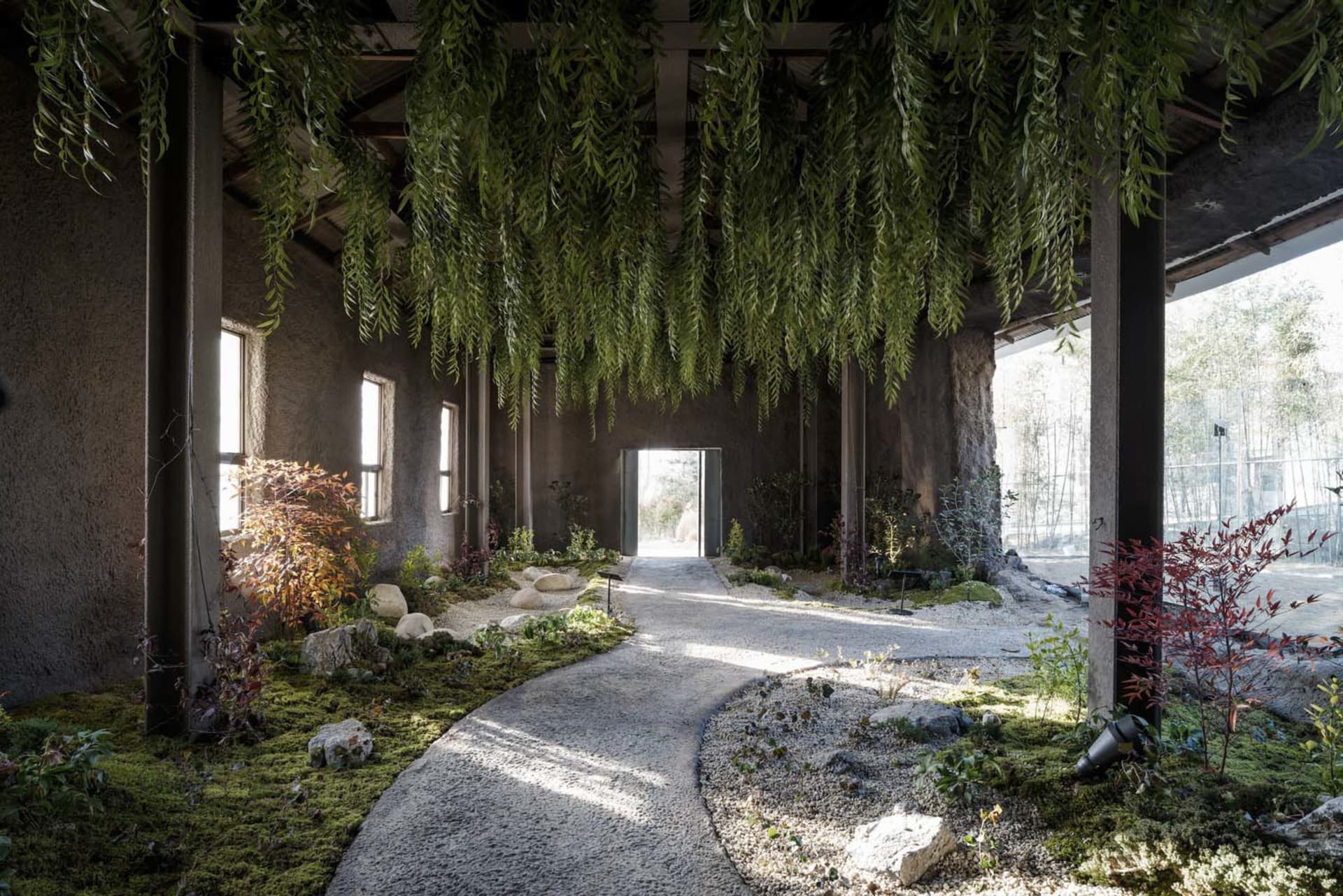 A lush indoor garden with a variety of plants, including trees and bushes, arranged in different positions with potted plants and artificial lighting