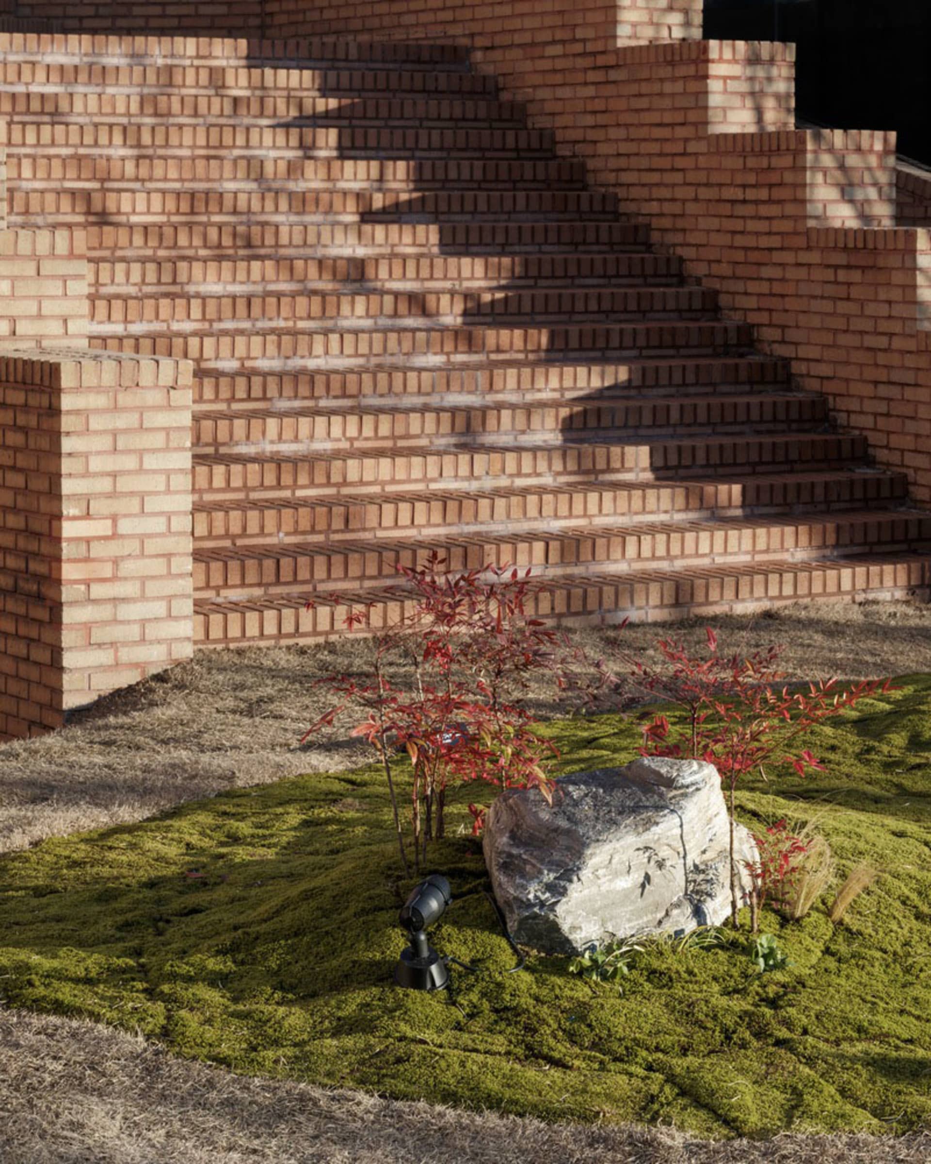 A brick staircase with three potted plants placed near the stairs, creating a calm and inviting atmosphere