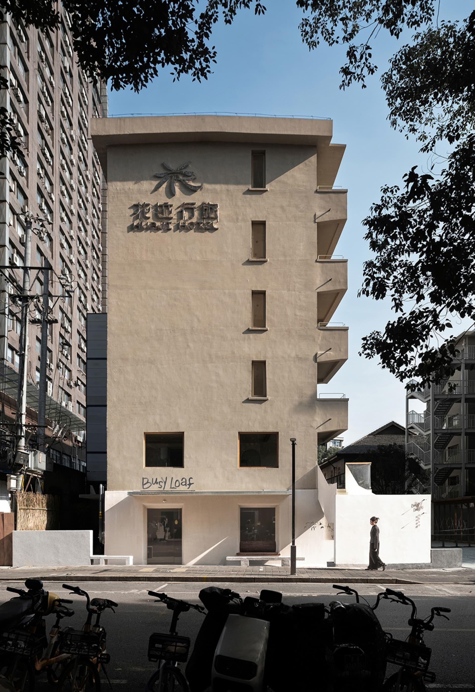 現代亞洲建築，白色混凝土立面，設有寬敞大廳區域，人們行走互動