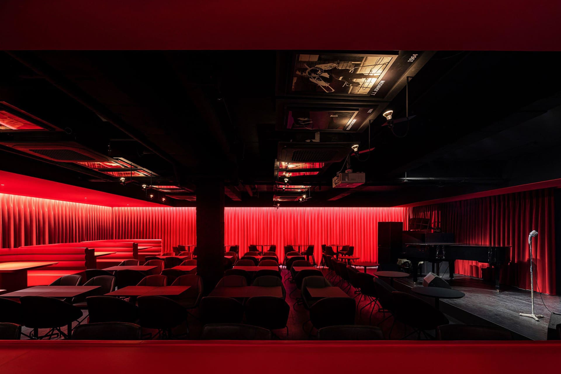 Cozy modern restaurant interior with red walls, black tables, and various chairs, creating a welcoming atmosphere