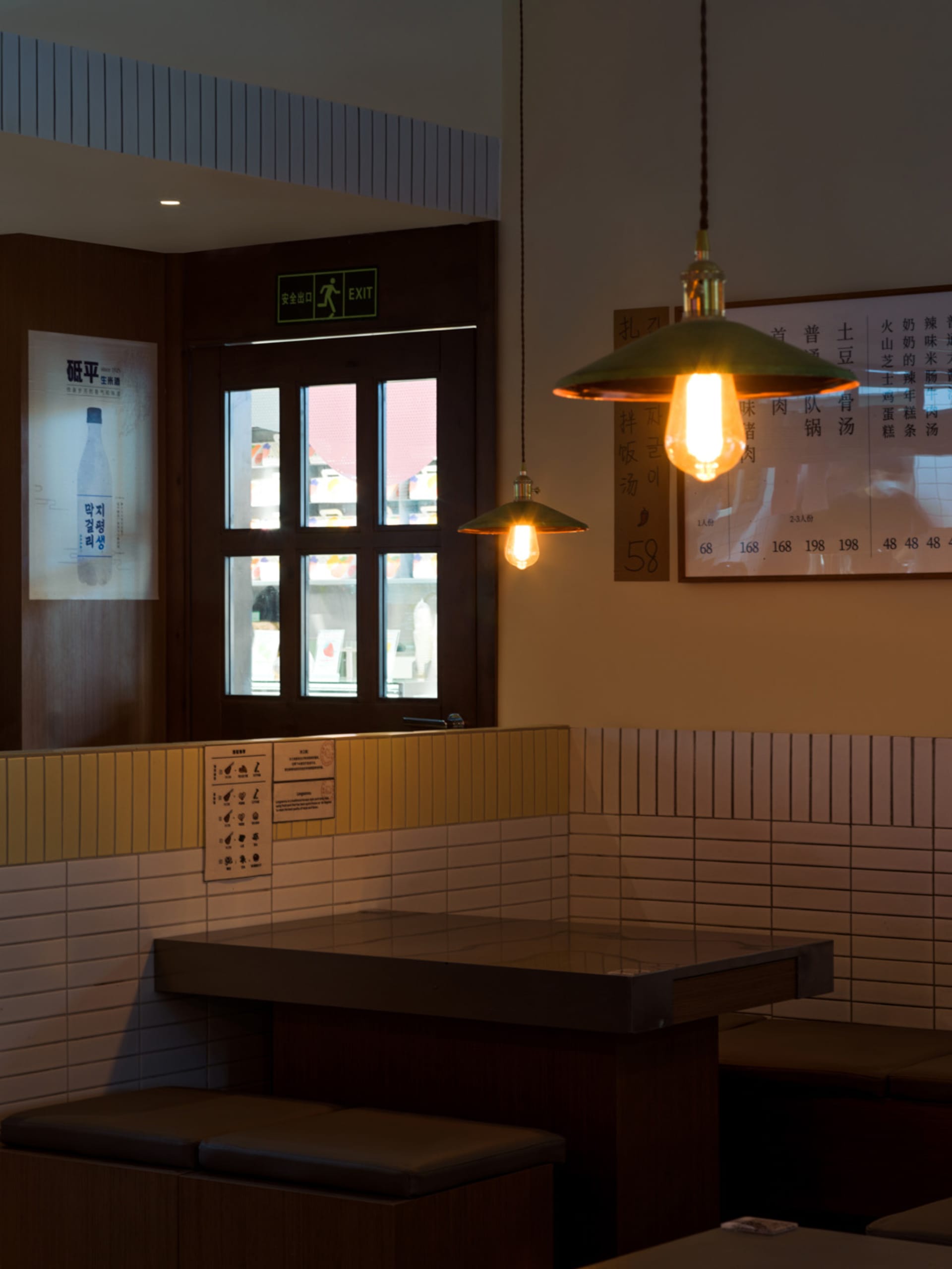 Cozy Asian restaurant interior with a long dining table, tiled walls, and hanging lights
