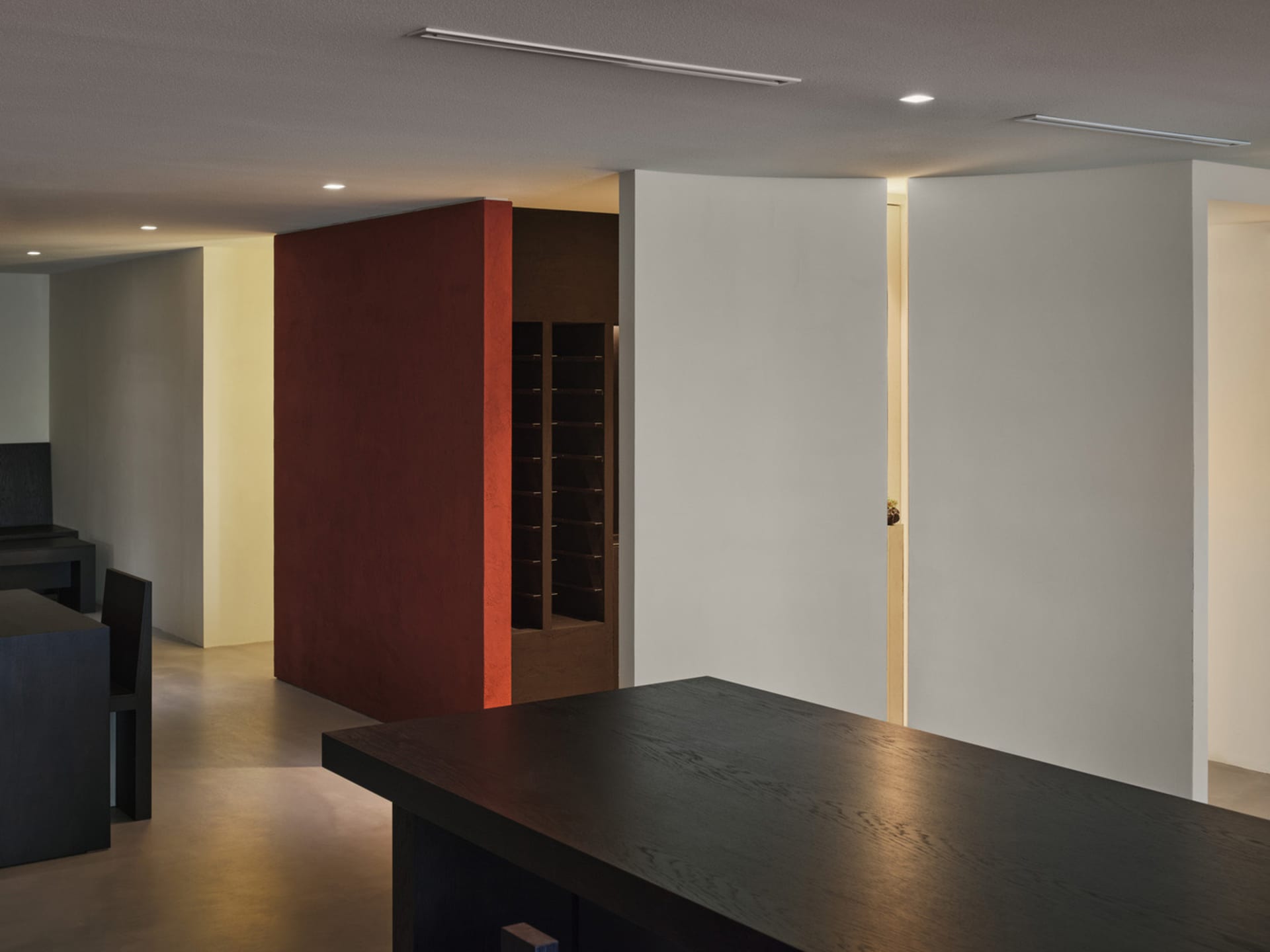 A modern kitchen with a black countertop, multicolored panels on the walls, and two doors, set in a well-lit space