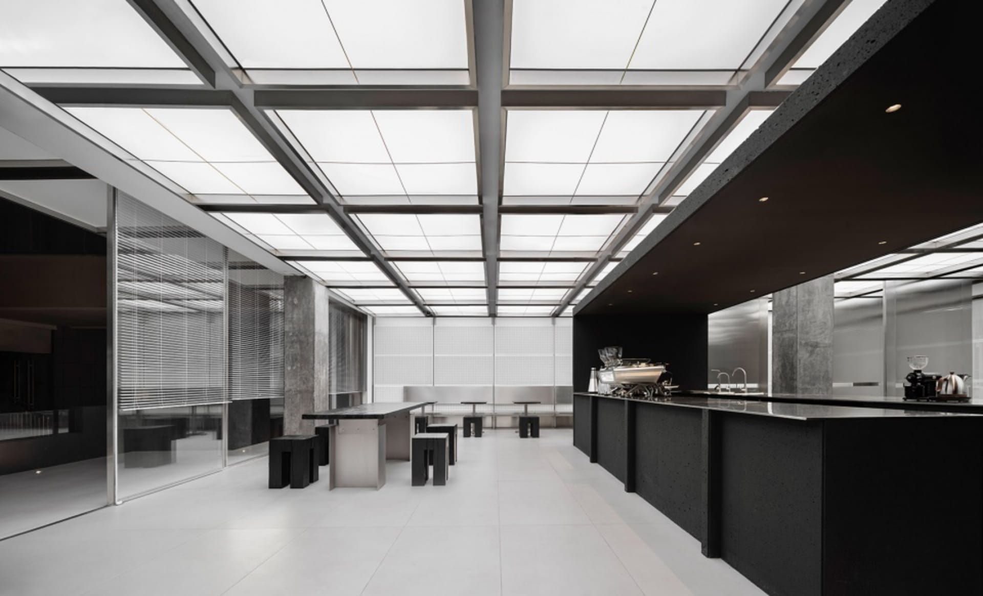 Modern restaurant interior with a large dining area, multiple tables, chairs, and couches, featuring a sleek and functional design