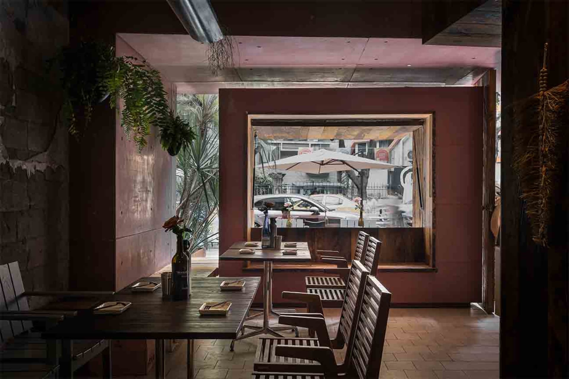 Dining area with tables, chairs, umbrellas, and wine glasses in a restaurant with a relaxed atmosphere