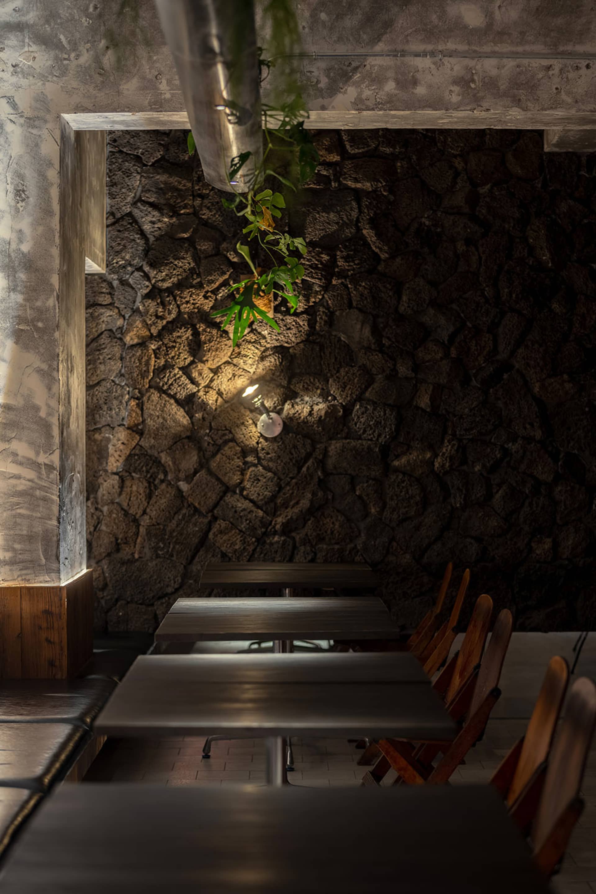 A restaurant dining area with multiple wooden tables and chairs arranged in rows, creating a comfortable seating arrangement for guests