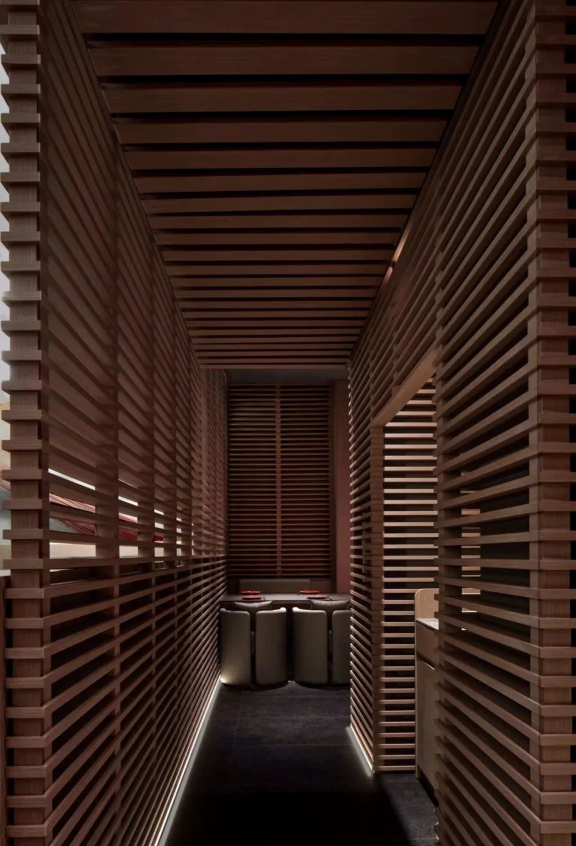 A modern kitchen dining space with wooden walls, a sink, and trash cans, featuring a functional and cozy atmosphere