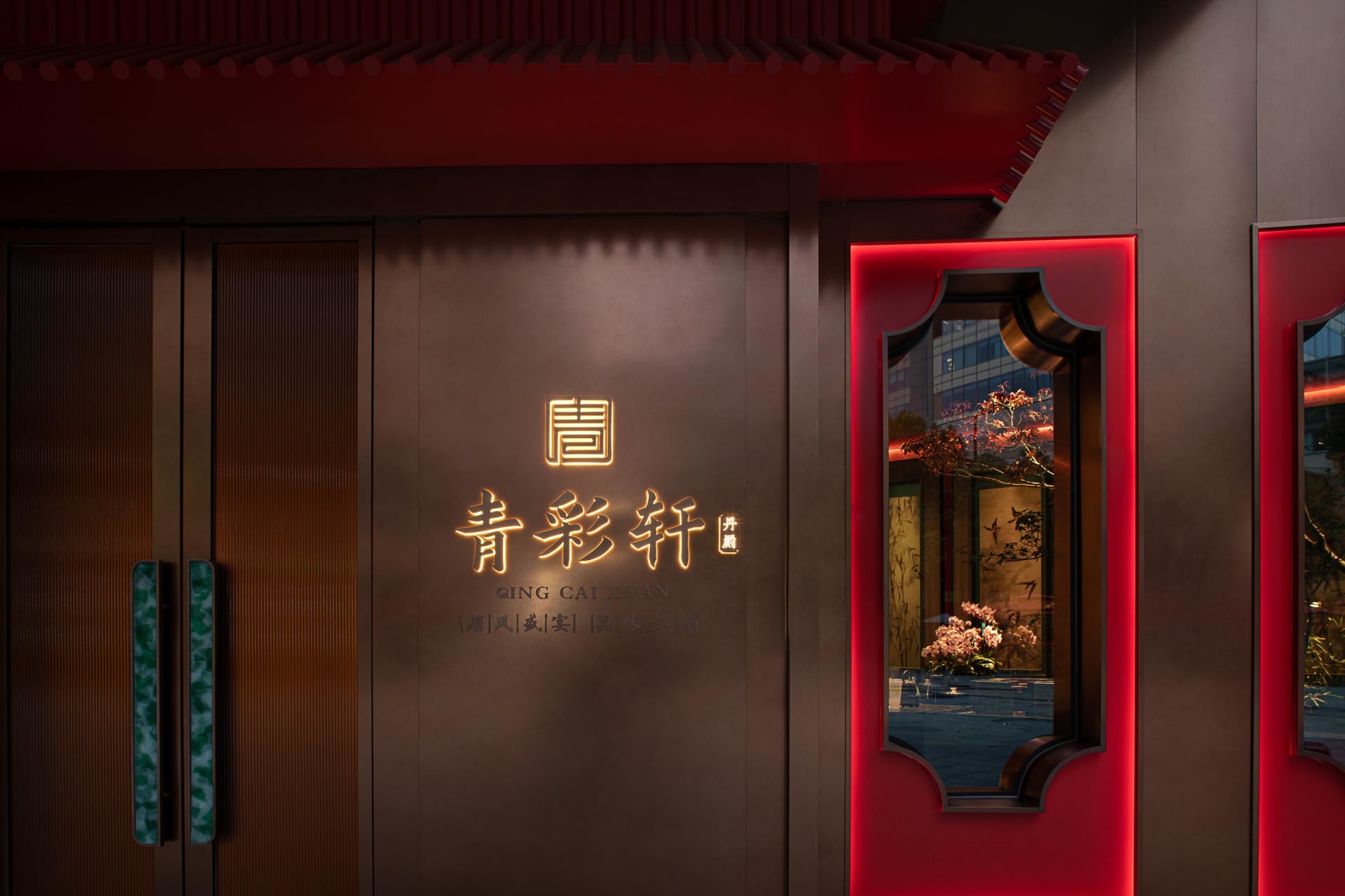 現代亞洲餐廳，擁有紅色牆面、大片窗戶與盆栽植物，搭配裝飾元素，營造溫馨氛圍