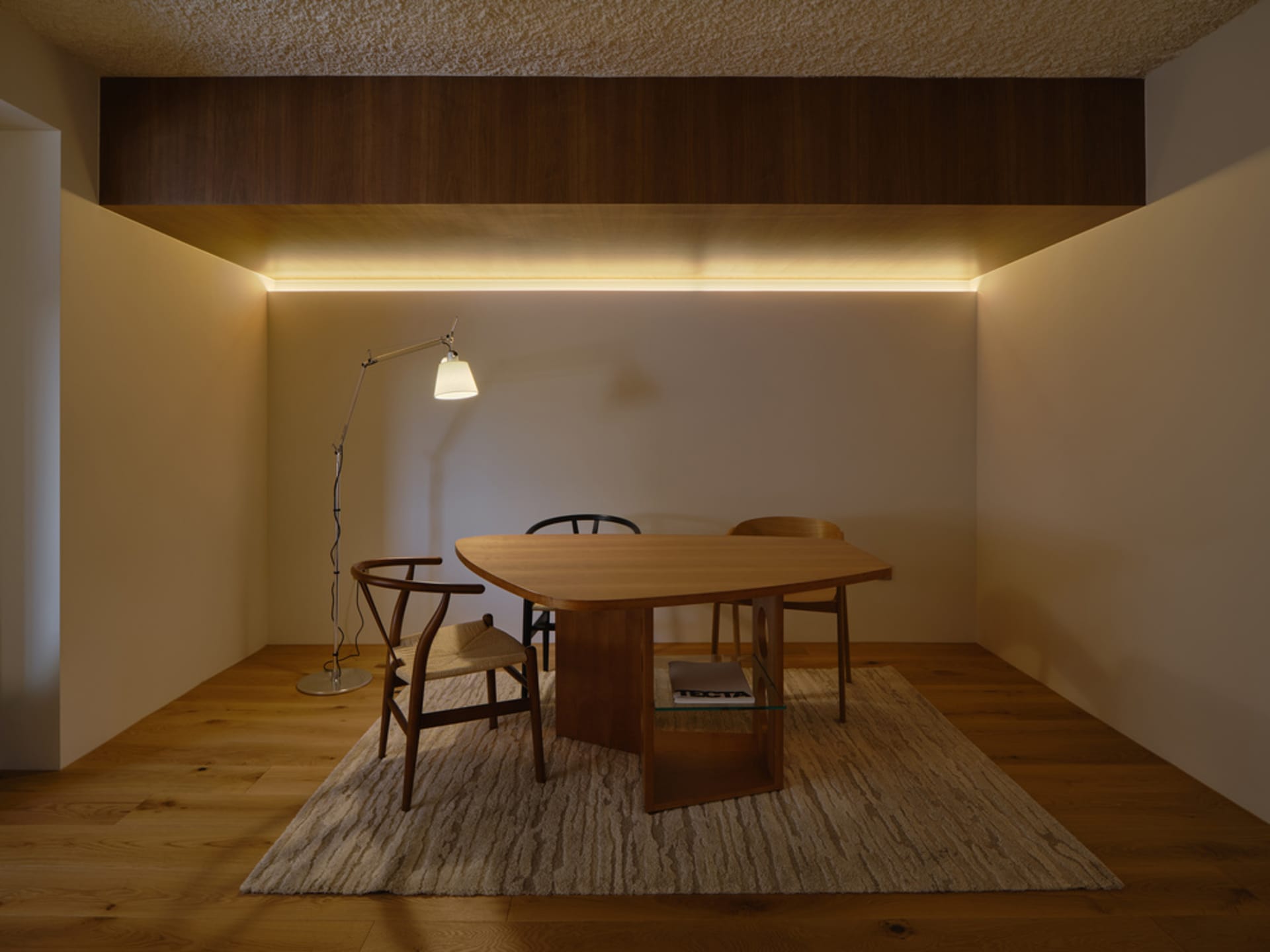 A well-lit living area with a wooden dining table and chairs, a couch, and a warm atmosphere