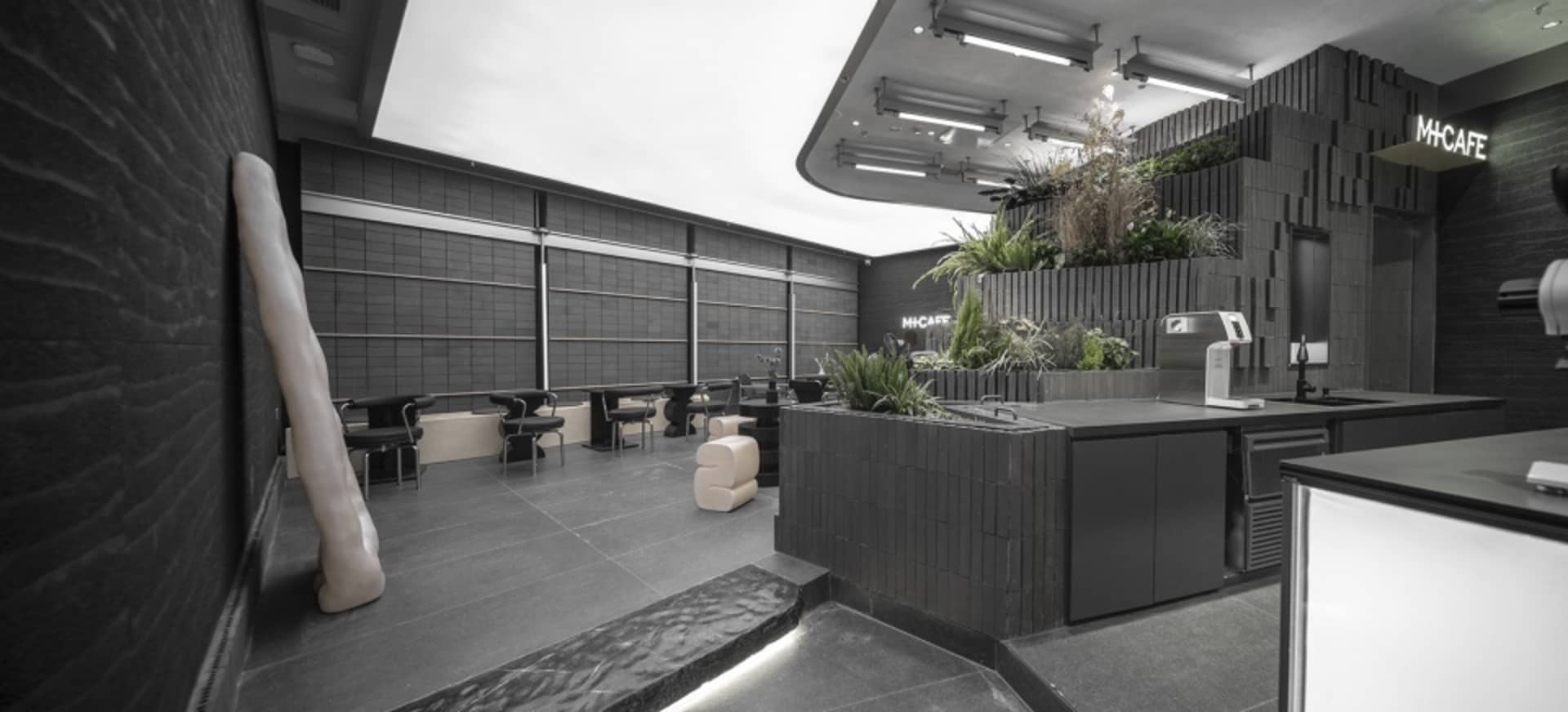 Modern cafe interior with tables, chairs, and potted plants, featuring a comfortable and inviting atmosphere