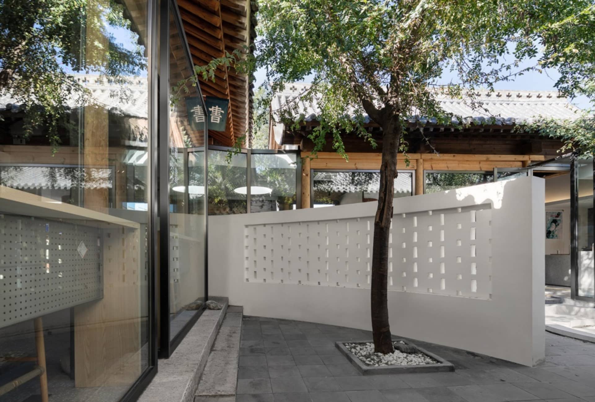 A building with white walls and a tree in front of it