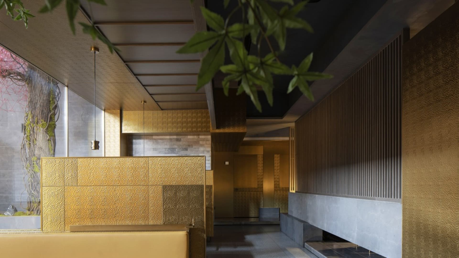 奢華飯店大廳，金色牆面與天花板、兩張長椅及盆栽，營造溫馨氛圍