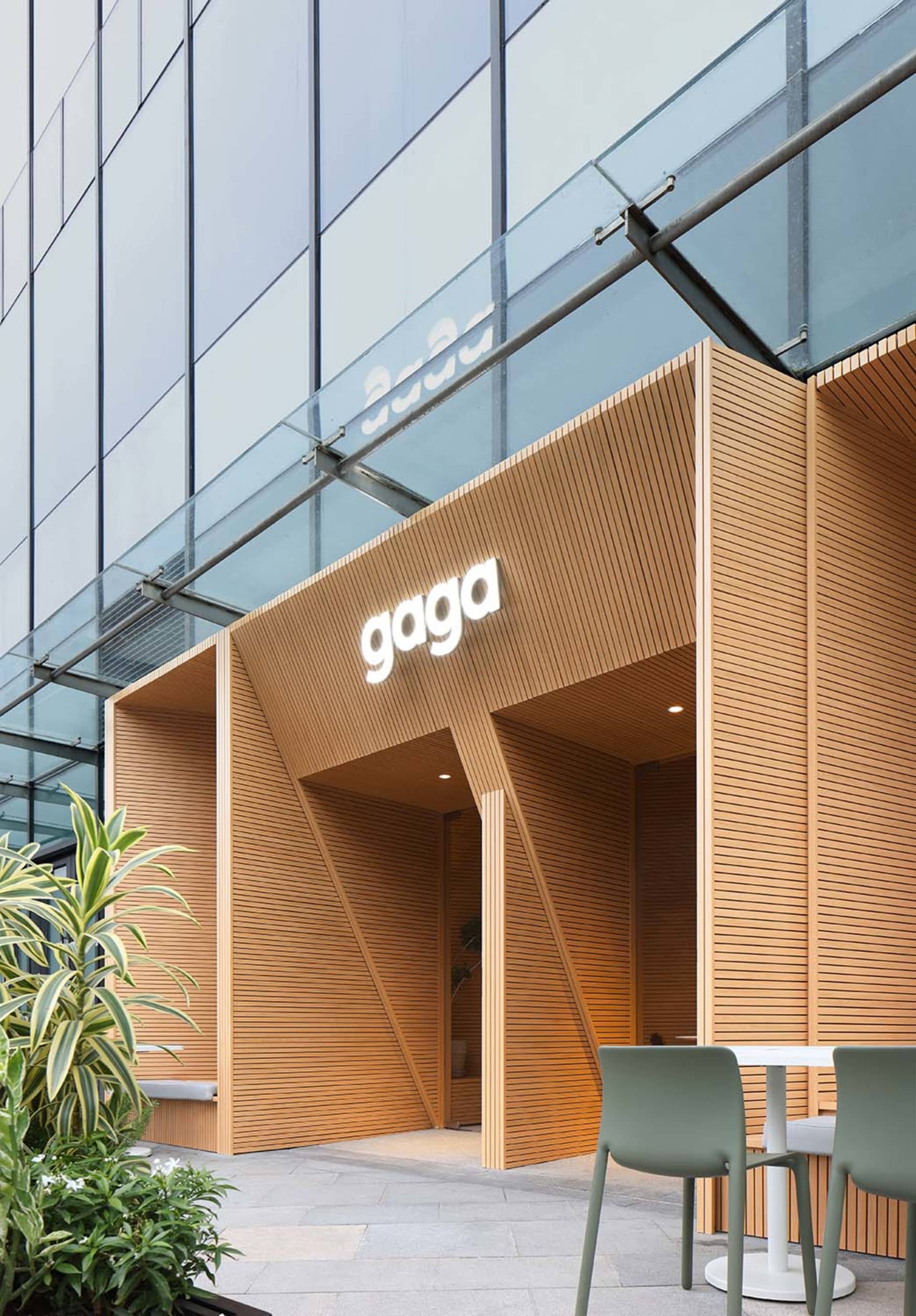 A modern restaurant with a wooden facade, featuring a comfortable and inviting atmosphere for patrons to enjoy their meals or drinks