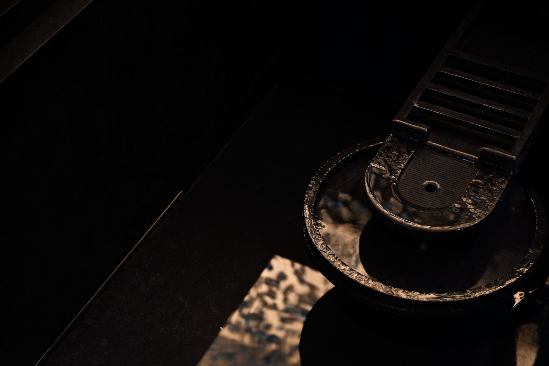 A dark and mysterious scene of a wooden tabletop with a circular object in the center, set against a plain background
