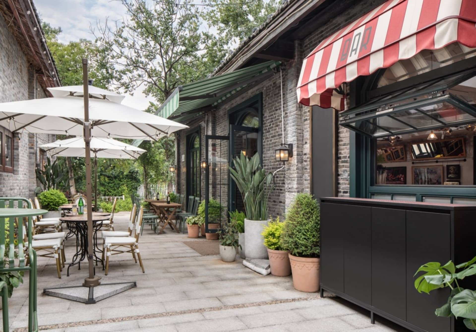 An outdoor dining area with tables, chairs, and potted plants, creating a relaxed and inviting atmosphere