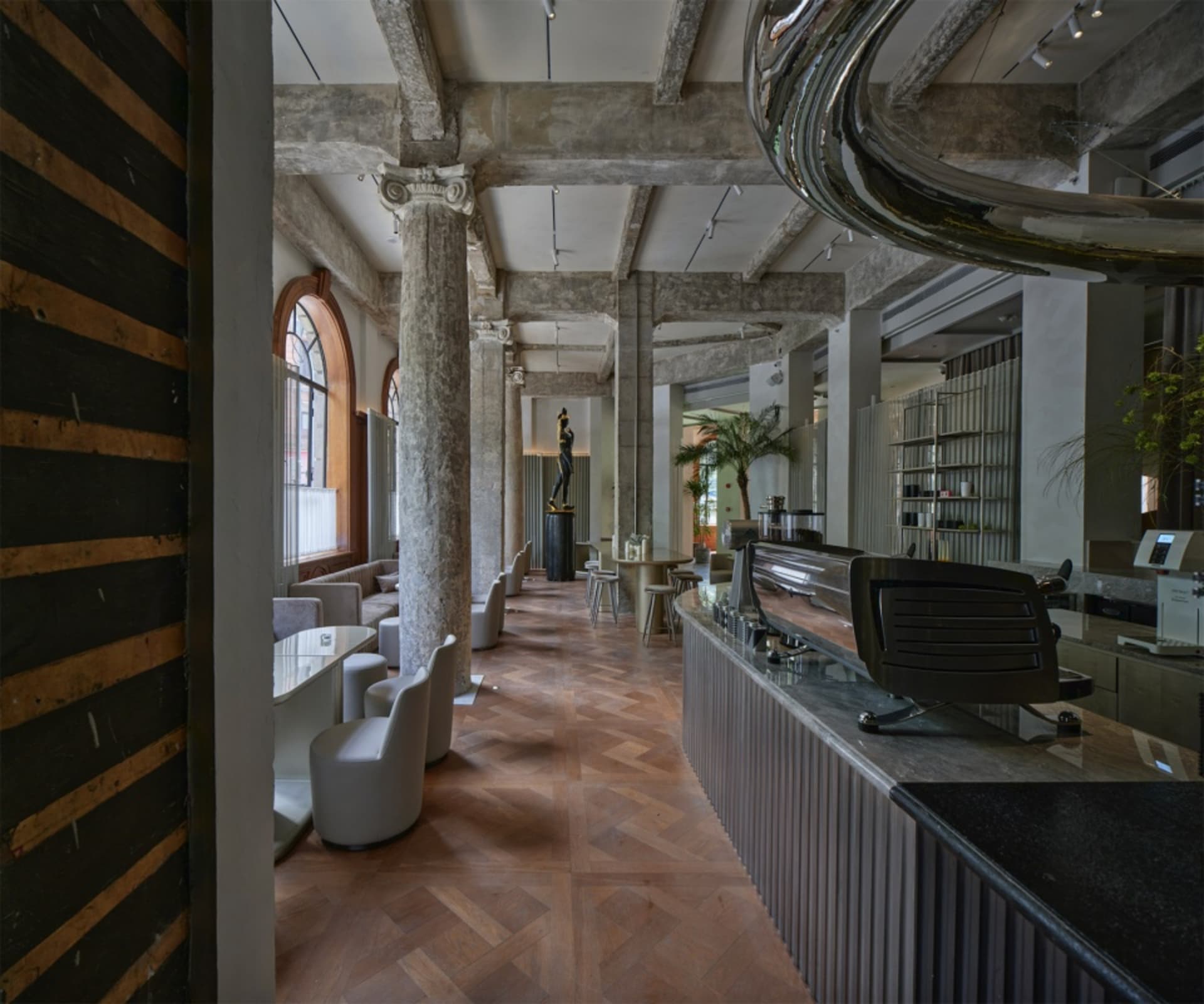 Elegant hotel lobby with high ceilings, chairs, a dining table, and vases, creating an inviting atmosphere