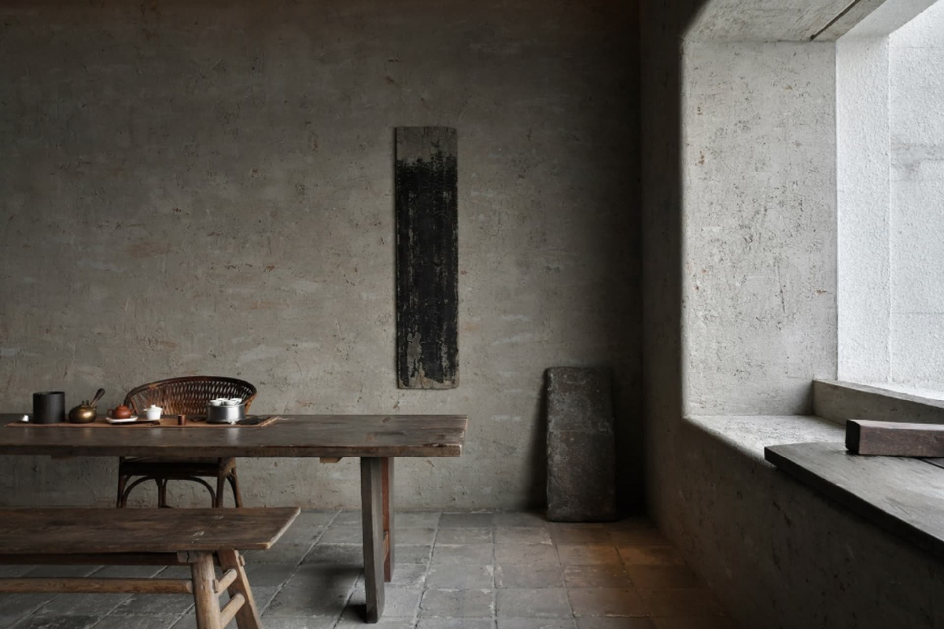 光線柔和的餐廳，石材紋理空間搭配木質餐桌與兩把椅子，桌上擺放碗與湯匙